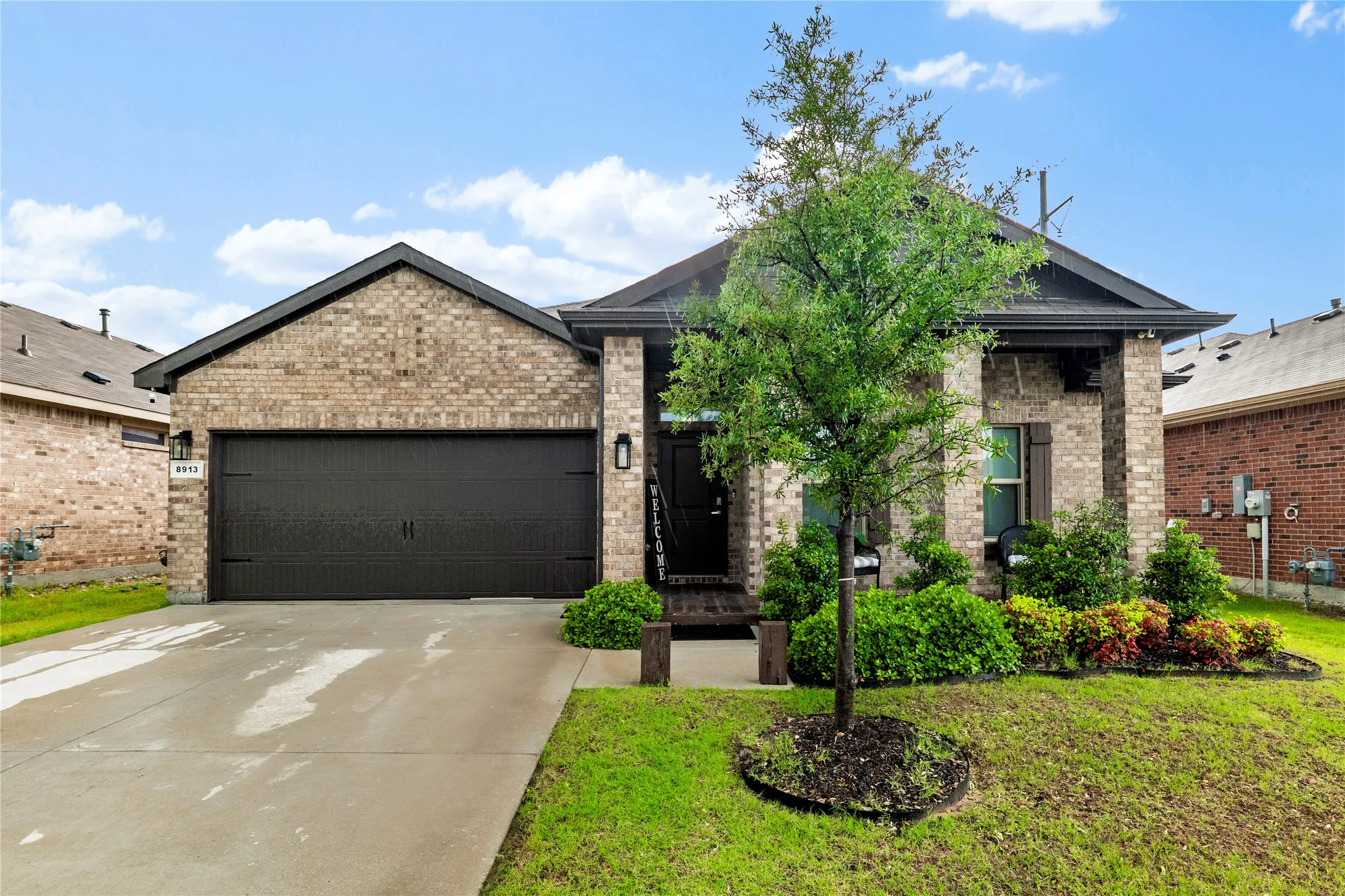 Brick exterior with a dark-pitched roof and a contrasting dark garage door