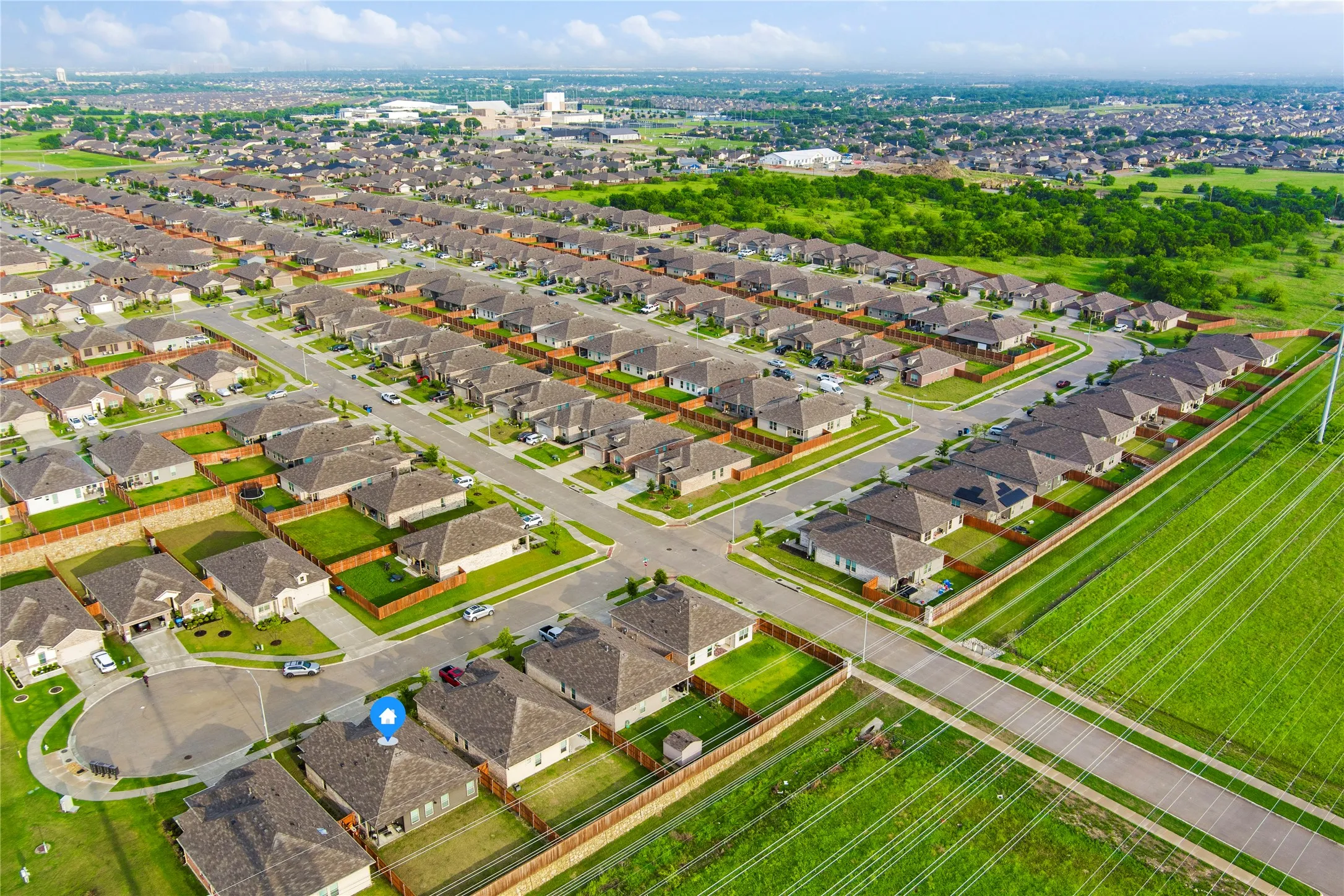 Aerial perspective of a developed residential area featuring numerous single-family homes with uniform rooflines and lot sizes