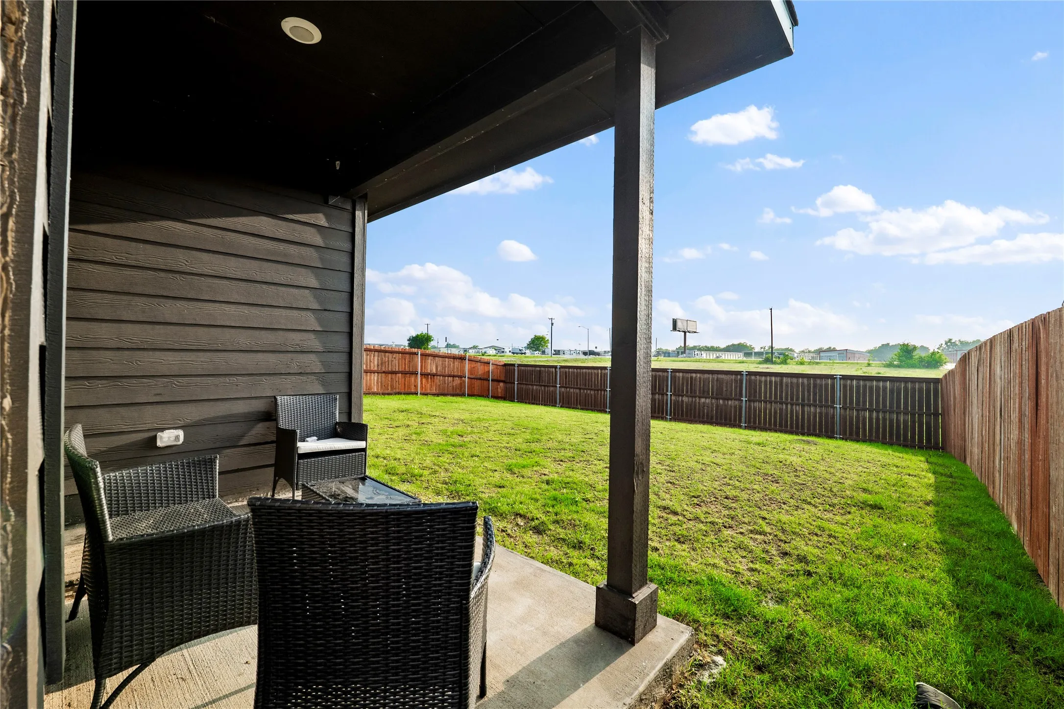 Covered patio with a concrete slab, recessed lighting, and a dark wood-paneled exterior