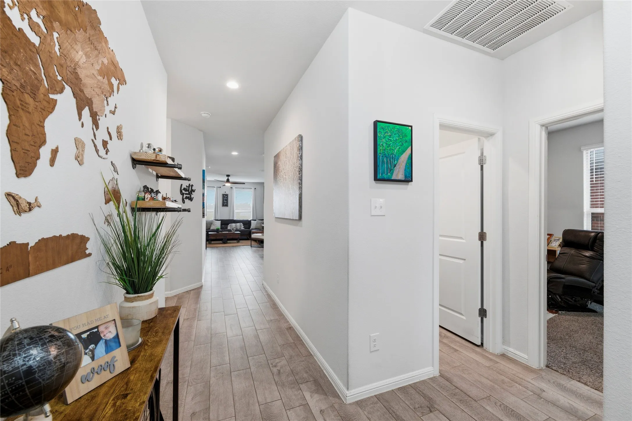 Hallway featuring wood-finish flooring, recessed lighting, and crisp white walls
