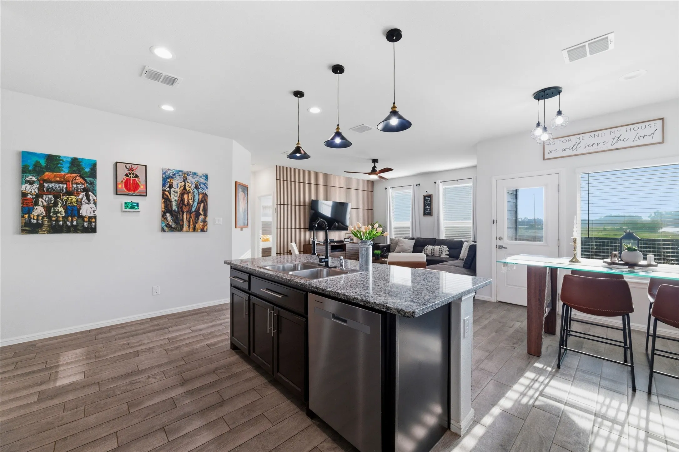 Kitchen island with a granite countertop, undermount sink, and stainless steel dishwasher