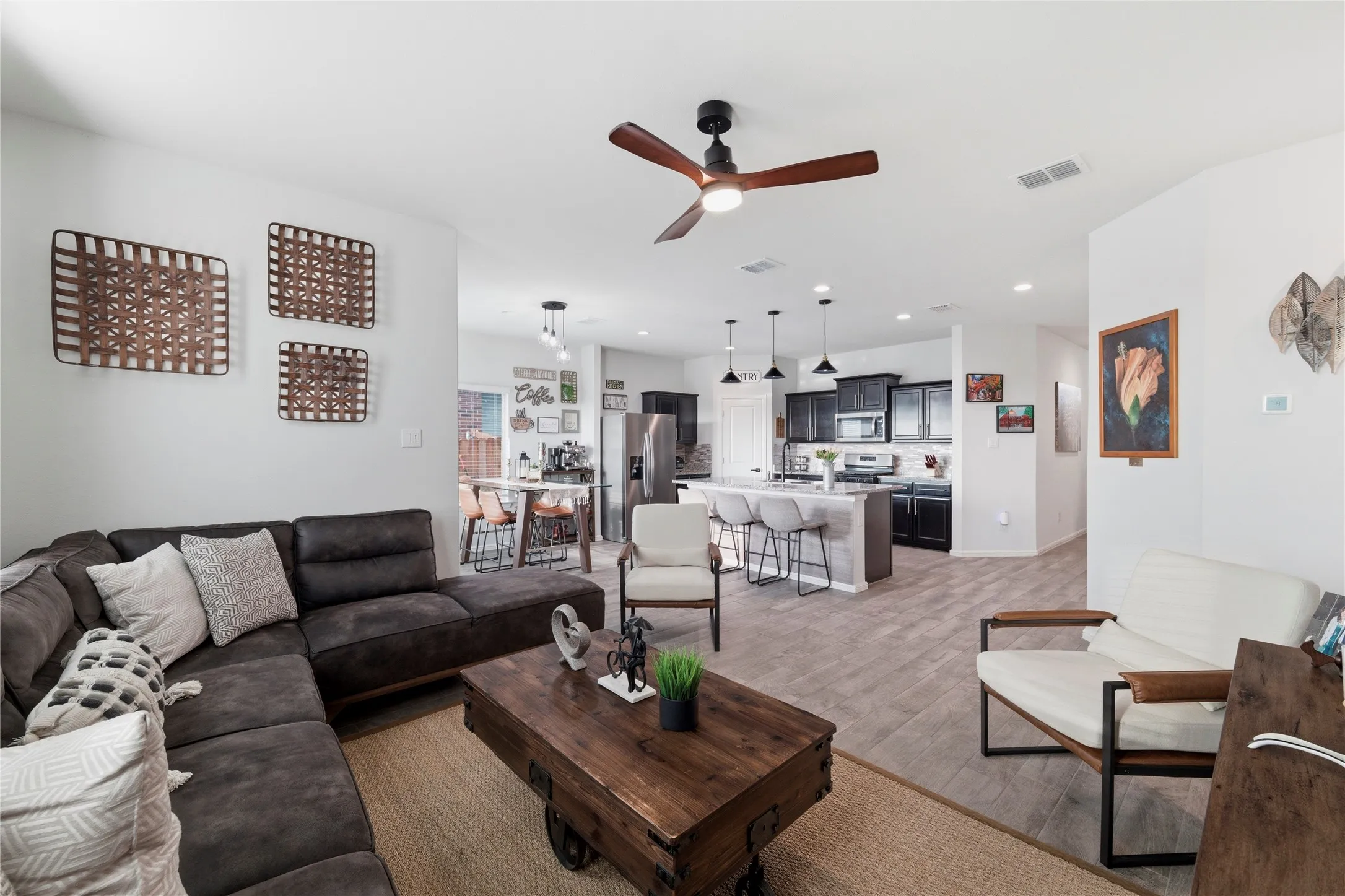 Open-concept living area featuring wood-finish flooring and a ceiling fan