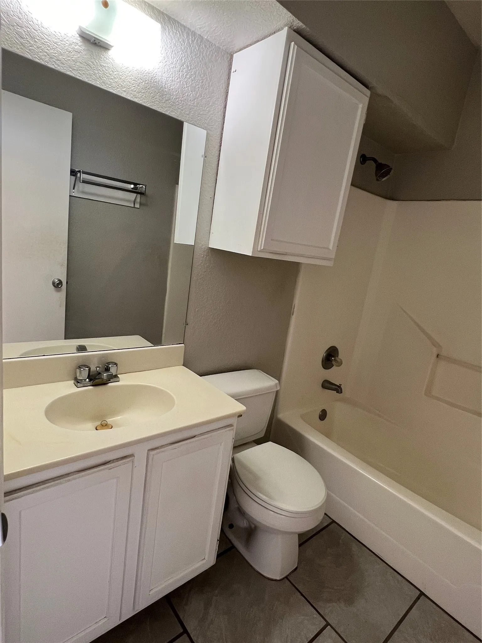 This bathroom has a dual show/tub combination. Notice the extra cabinet over the toilet.