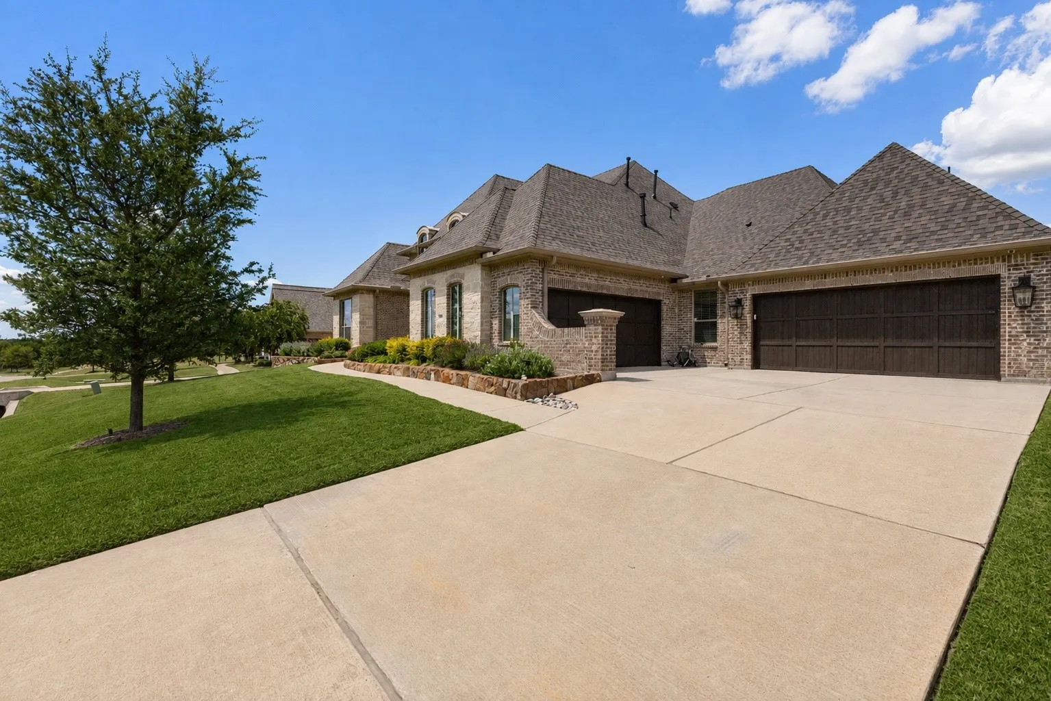 Note the 4 car garage (2 garages with 2 spaces each). One garage is climate controlled for hobbyists, gym space or an art studio. Find custom cabinetry in the garage as well.