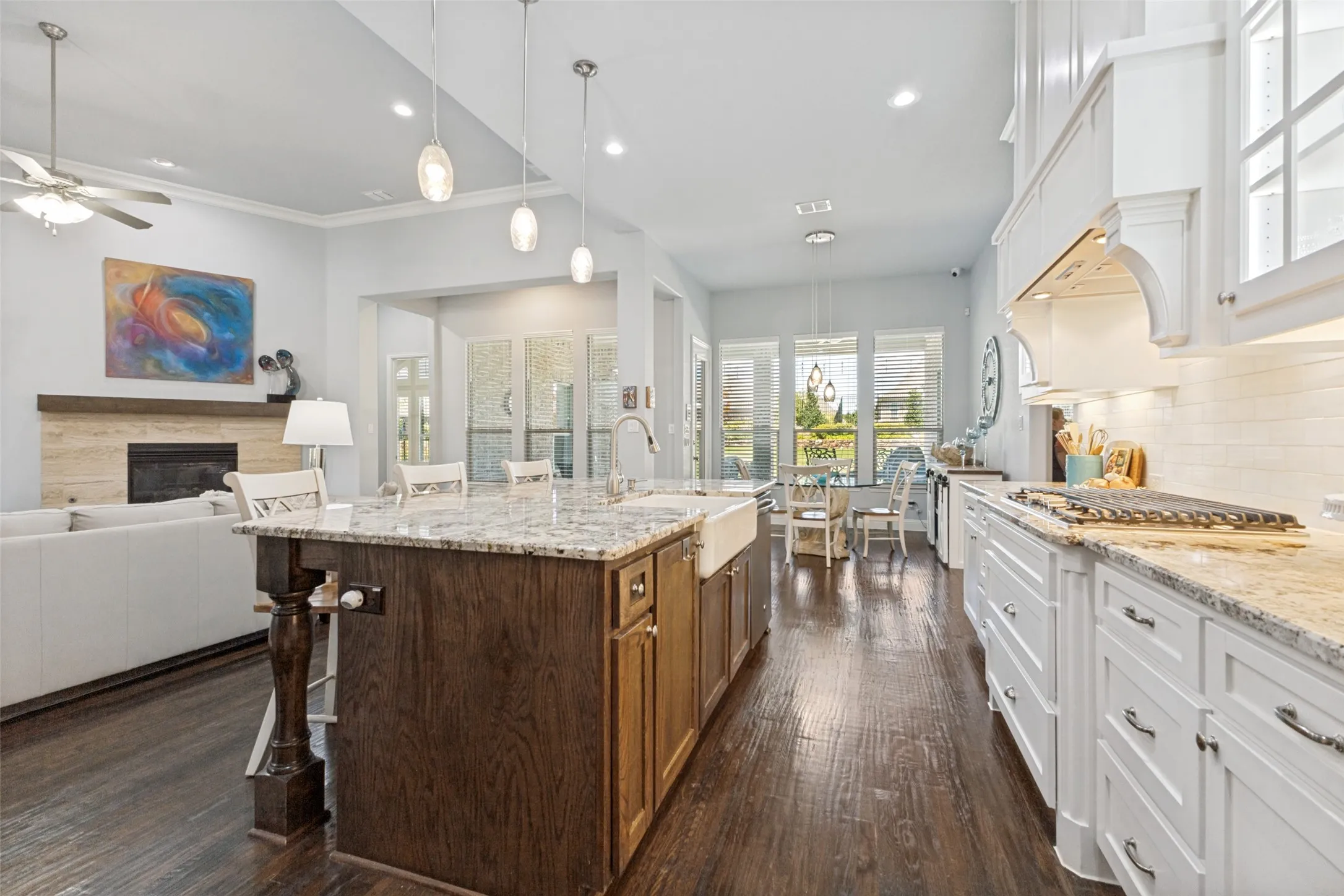 Kitchen featuring a farmhouse sink, granite countertops, an island with seating, a gas cooktop, and a mudroom.