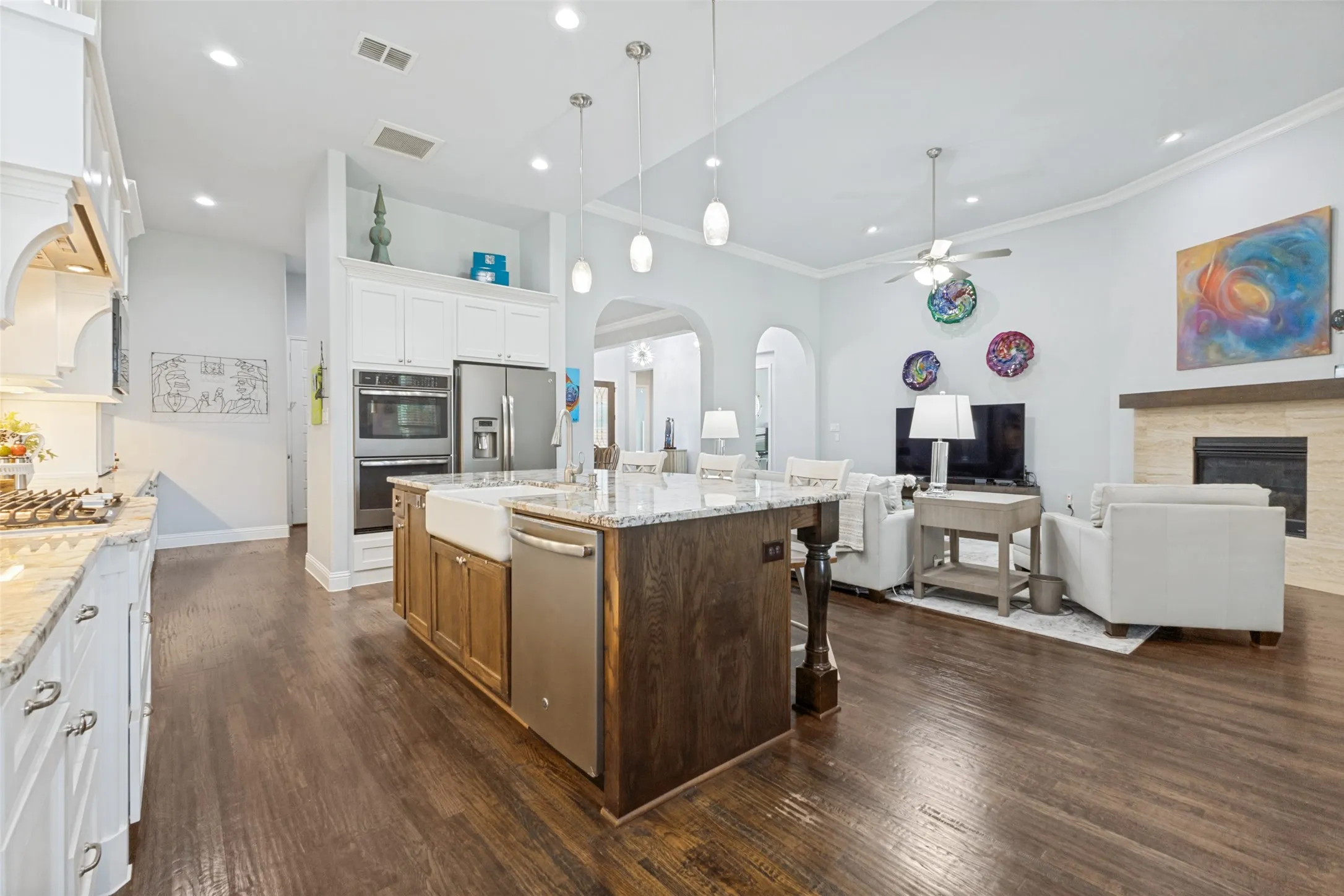 Kitchen featuring a farmhouse sink, granite countertops, an island with seating, a gas cooktop, and a mudroom.