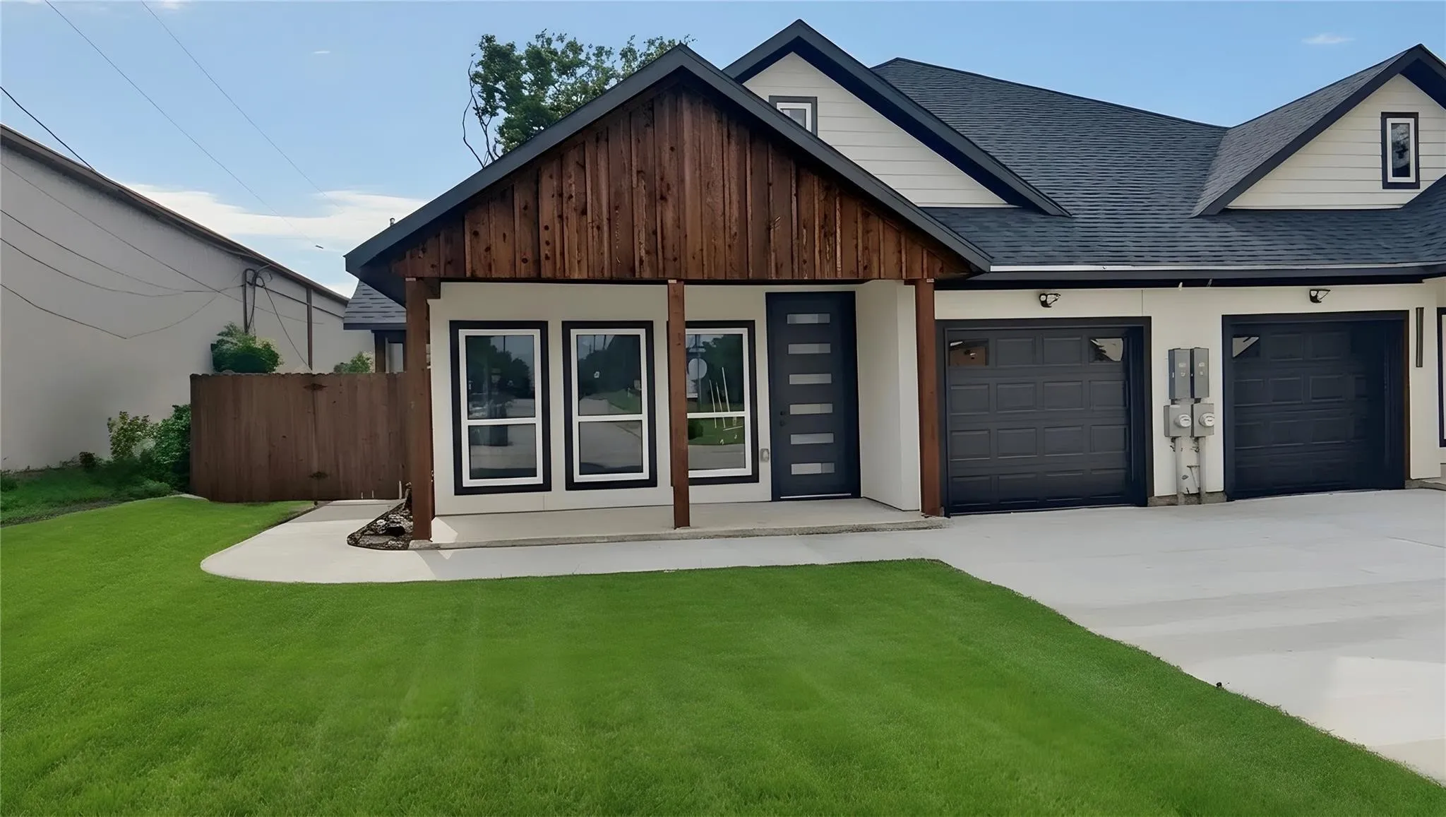 Contemporary architectural design featuring a prominent front gable with wood siding, crisp white exterior, and a dark asphalt shingle roof