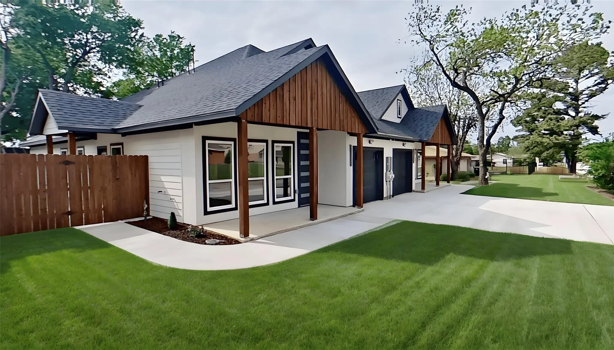 Modern farmhouse-style exterior featuring white siding, dark trim, and natural wood accents