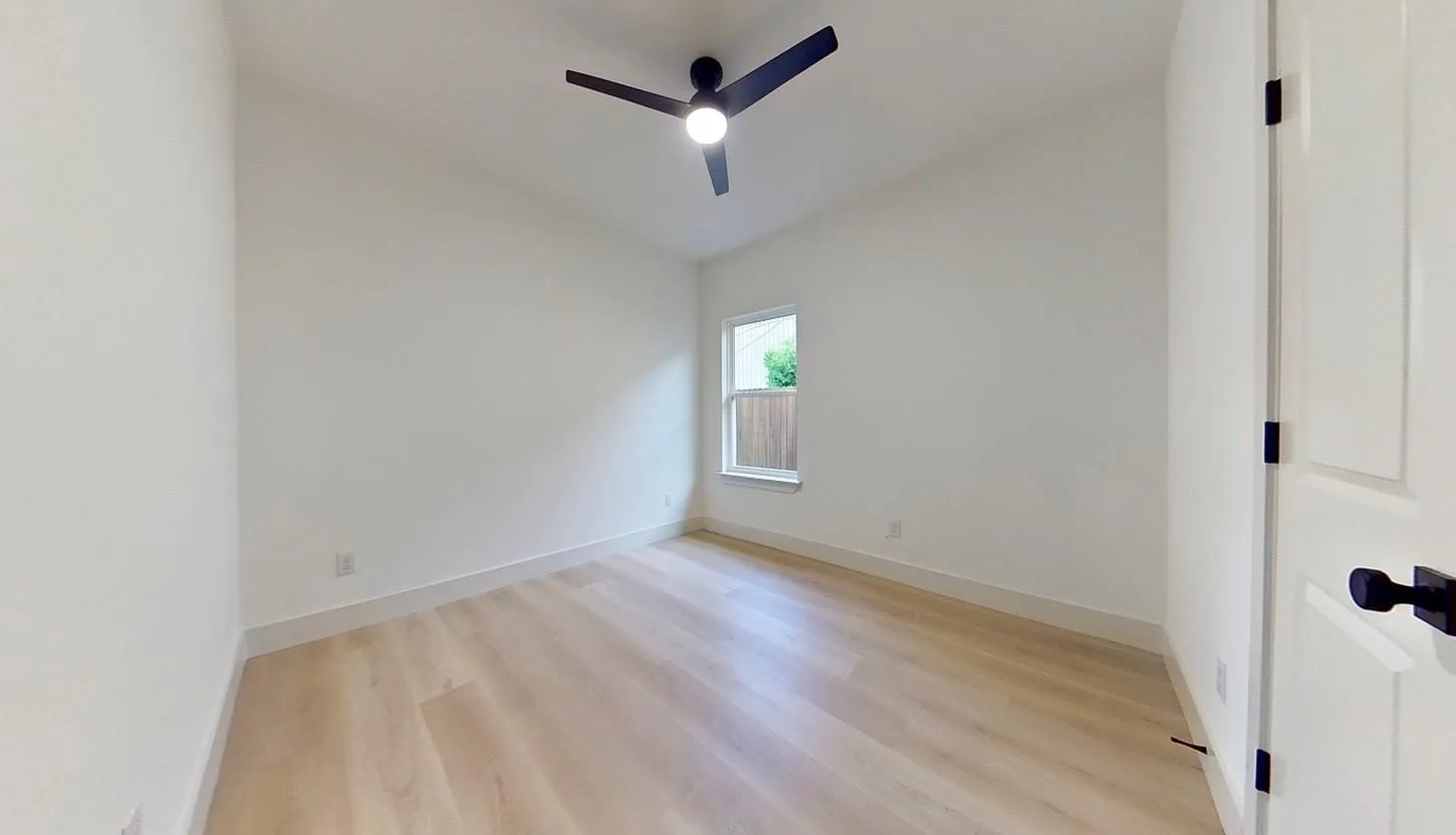 Room featuring light wood-finish flooring, white walls, and a contemporary ceiling fan