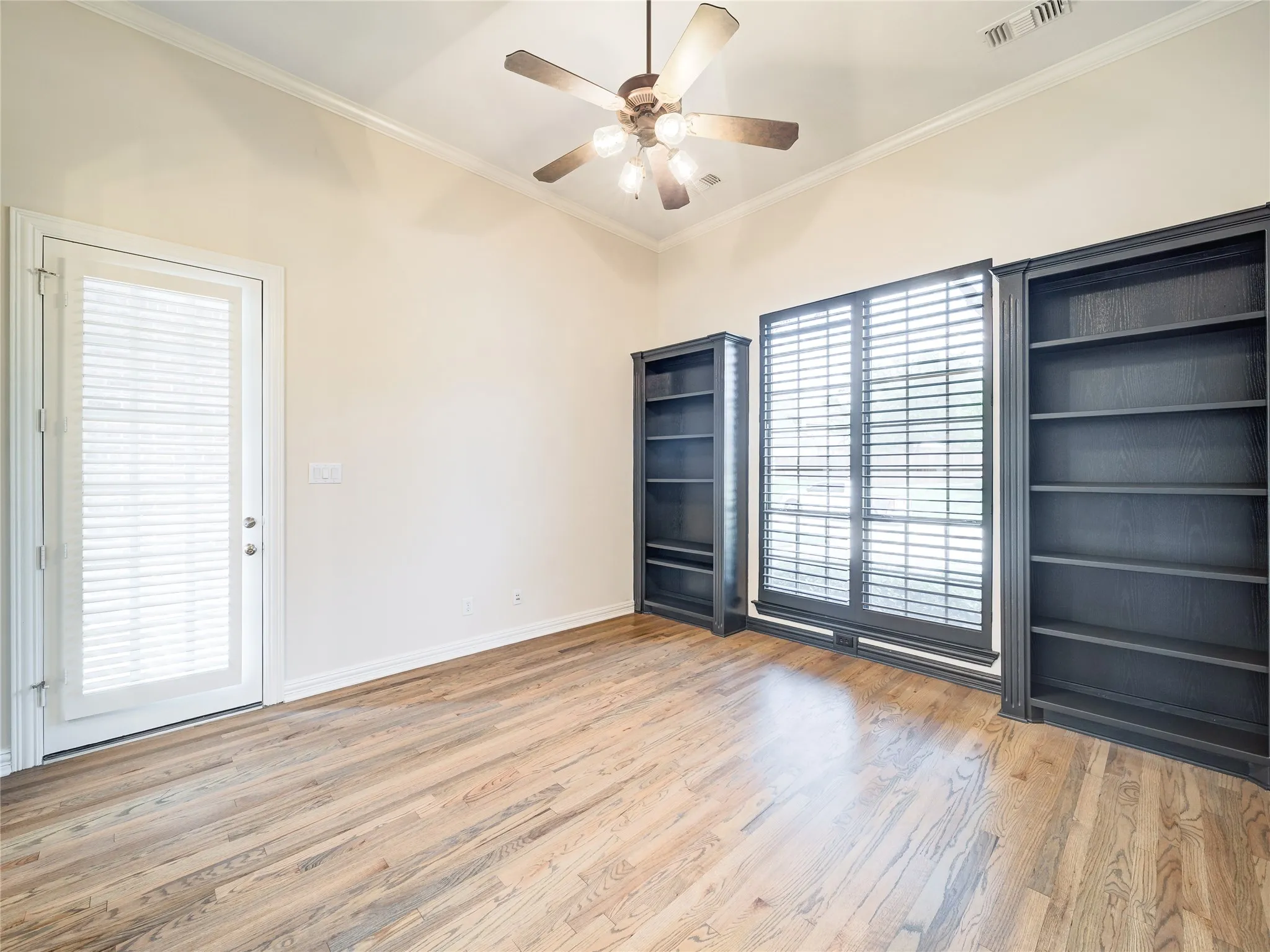 Room featuring wood-finish flooring, vaulted ceiling, and crown molding