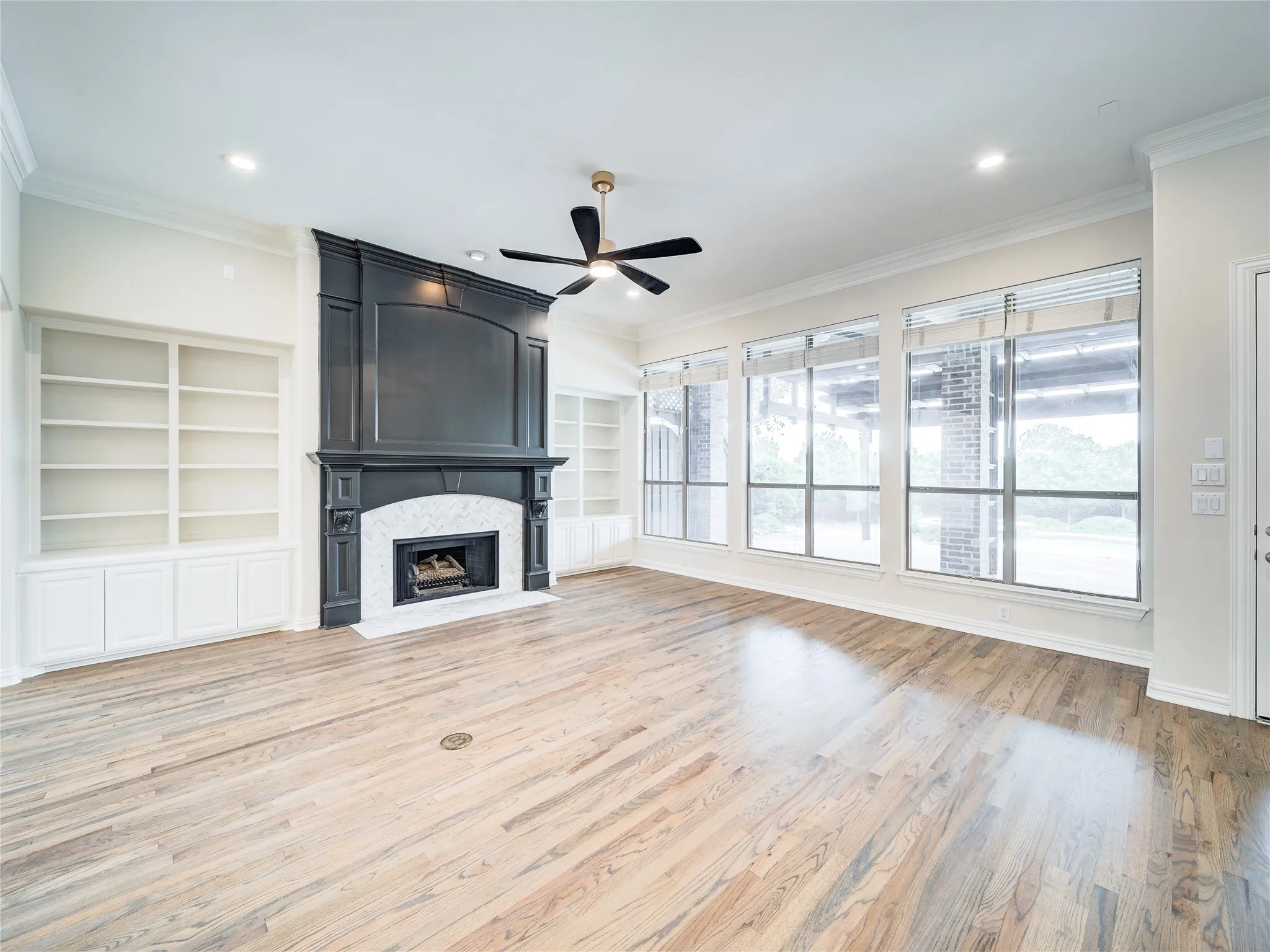 Spacious living area featuring a dark wood-finish fireplace surround with a white marble-look tile hearth