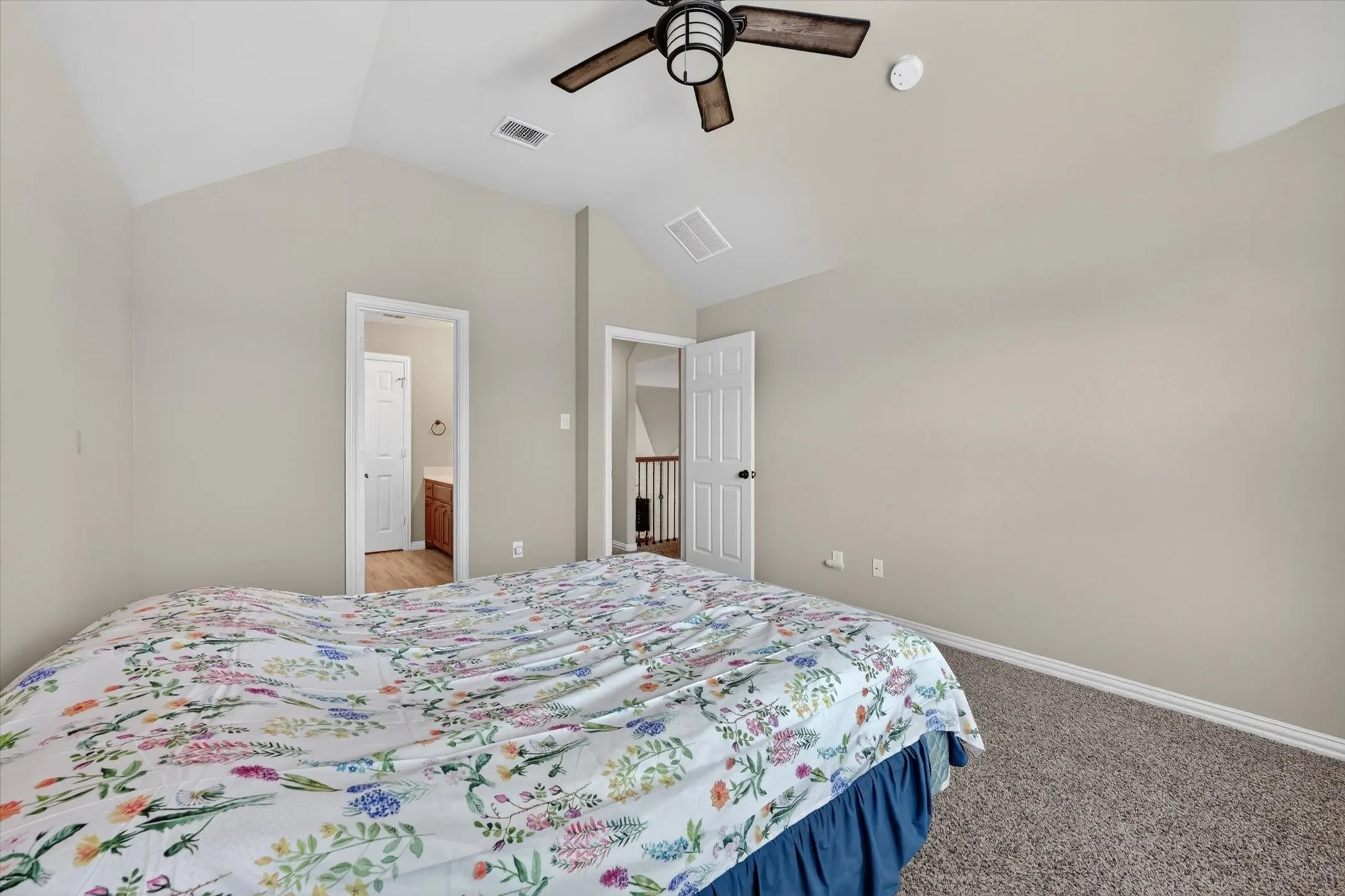 Vaulted ceilings with a ceiling fan, neutral wall tones, and plush carpet flooring