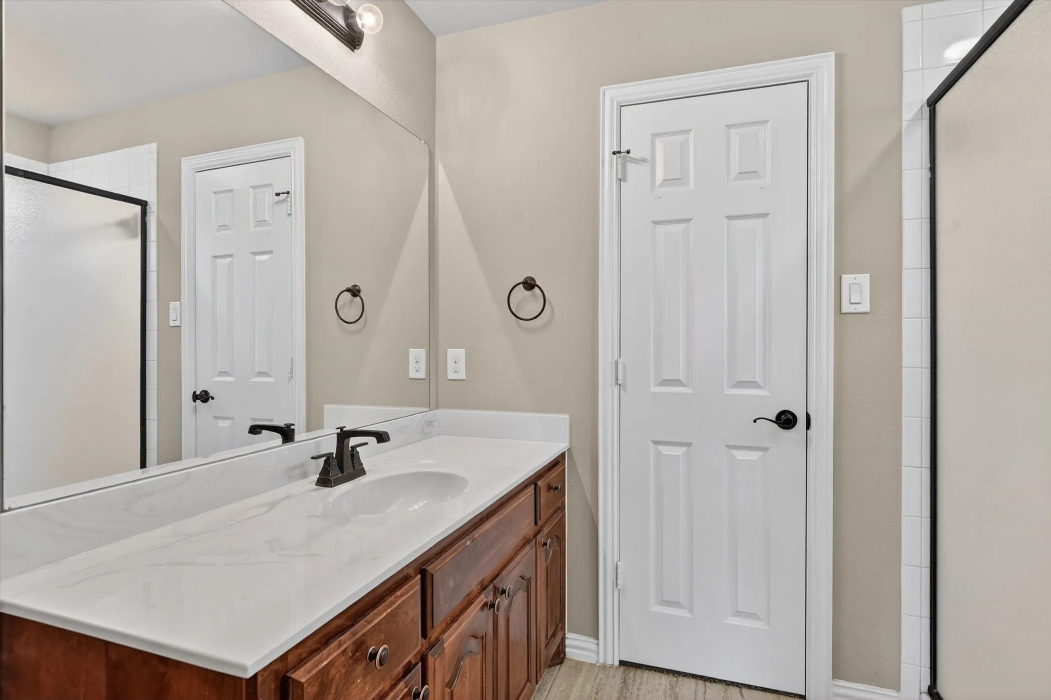 Vanity featuring a white countertop, undermount sink, and dark bronze faucet