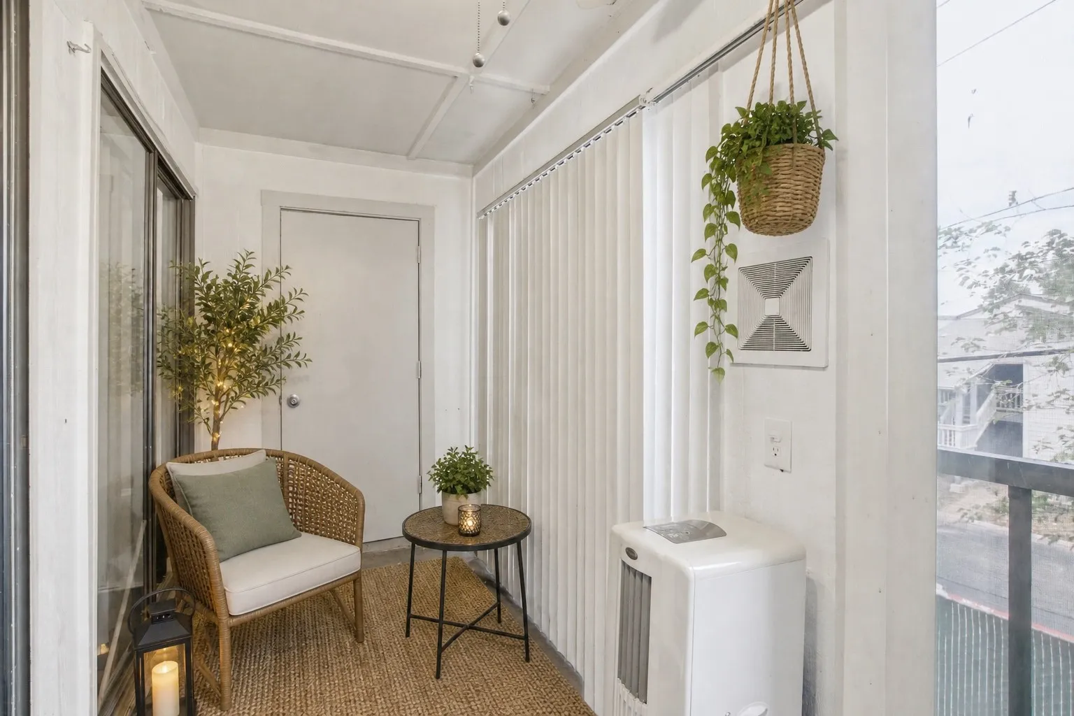 Sunroom featuring a neutral color palette, sliding glass door, solid white door, and woven rug flooring
