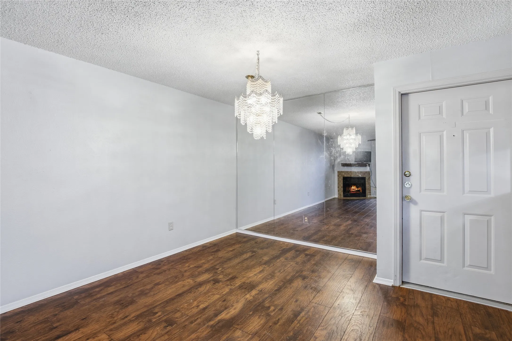Wood-finish flooring throughout, complemented by a white paneled entry door