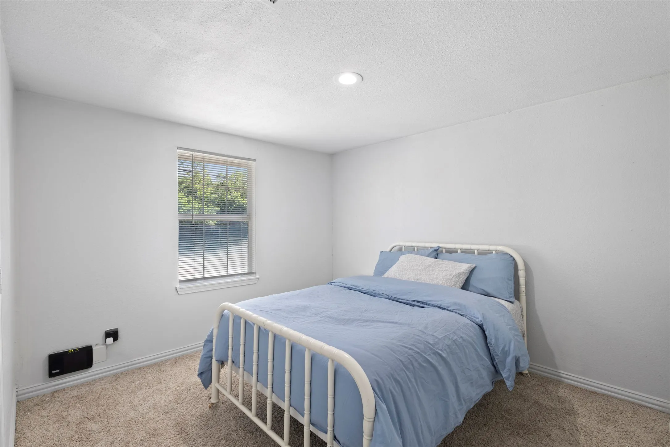 Secondary bedroom, offering generous space for full bed and lots of natural light.