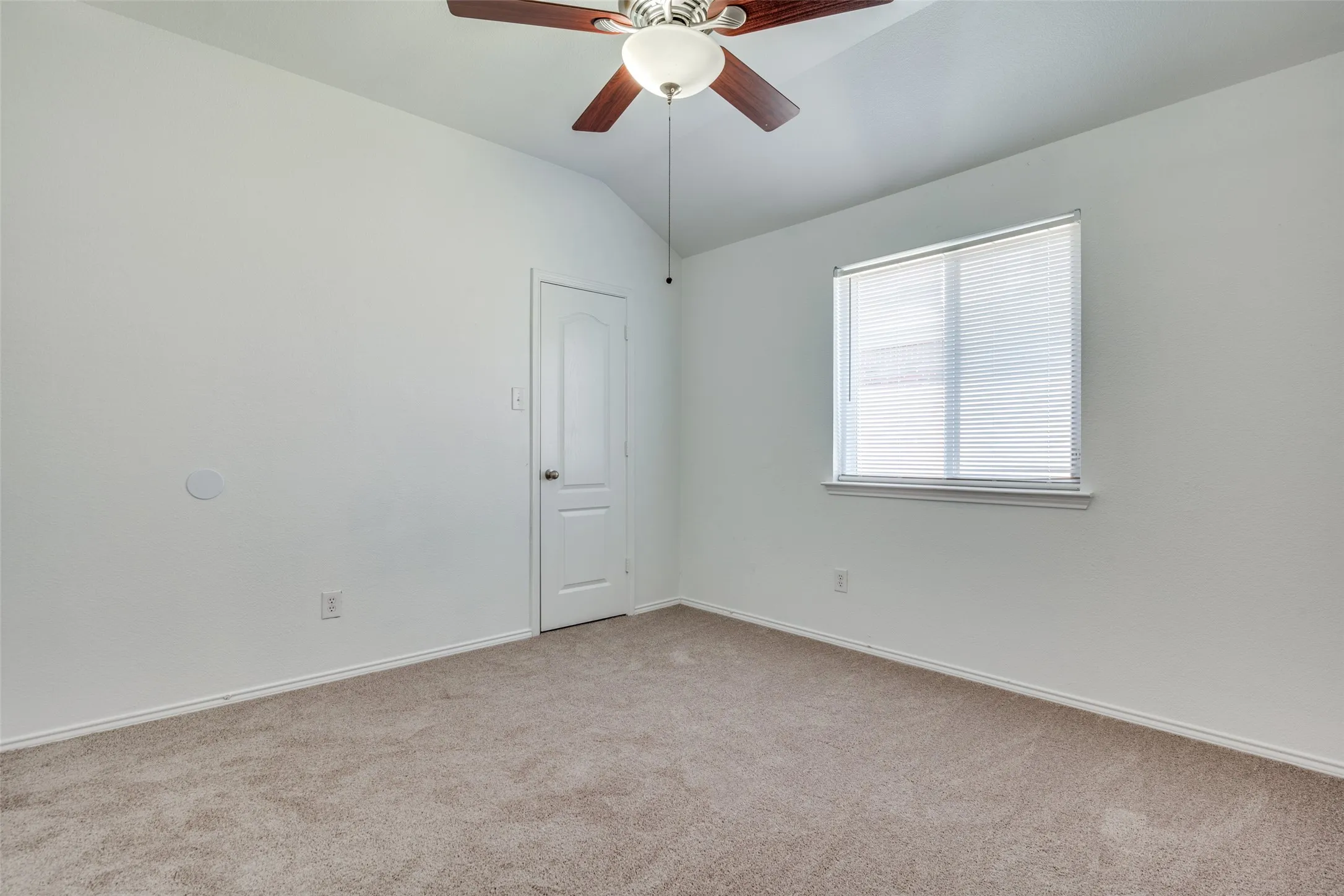 Unfurnished room featuring light carpet, lofted ceiling, and ceiling fan