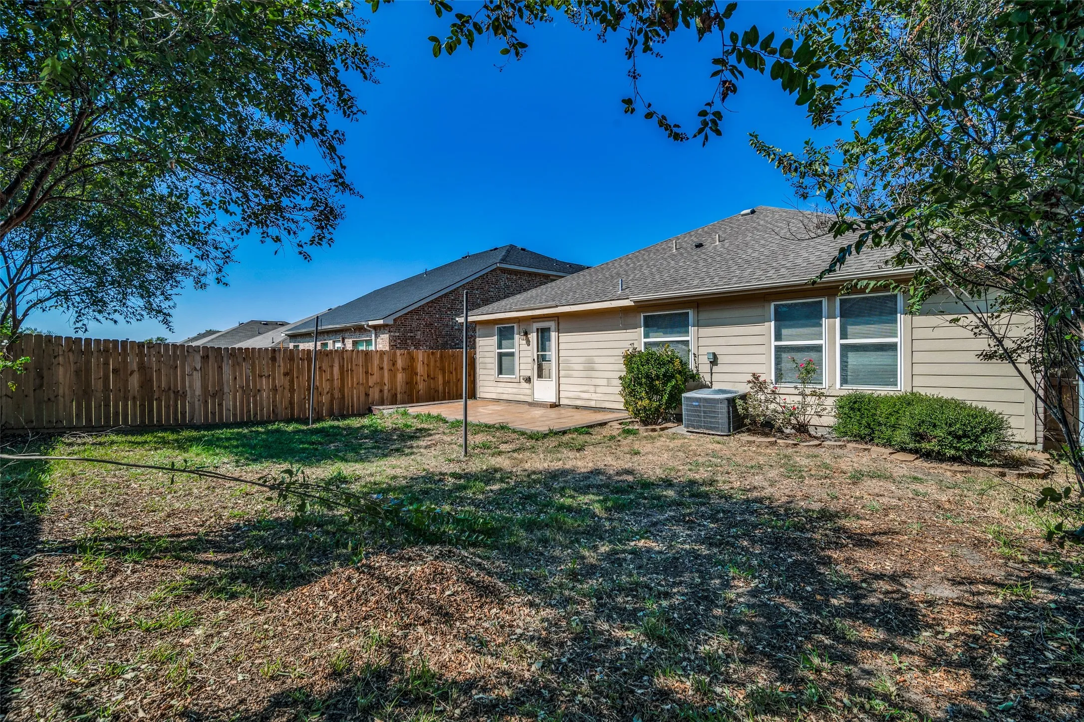 Rear view of property with a patio, central AC, and a yard