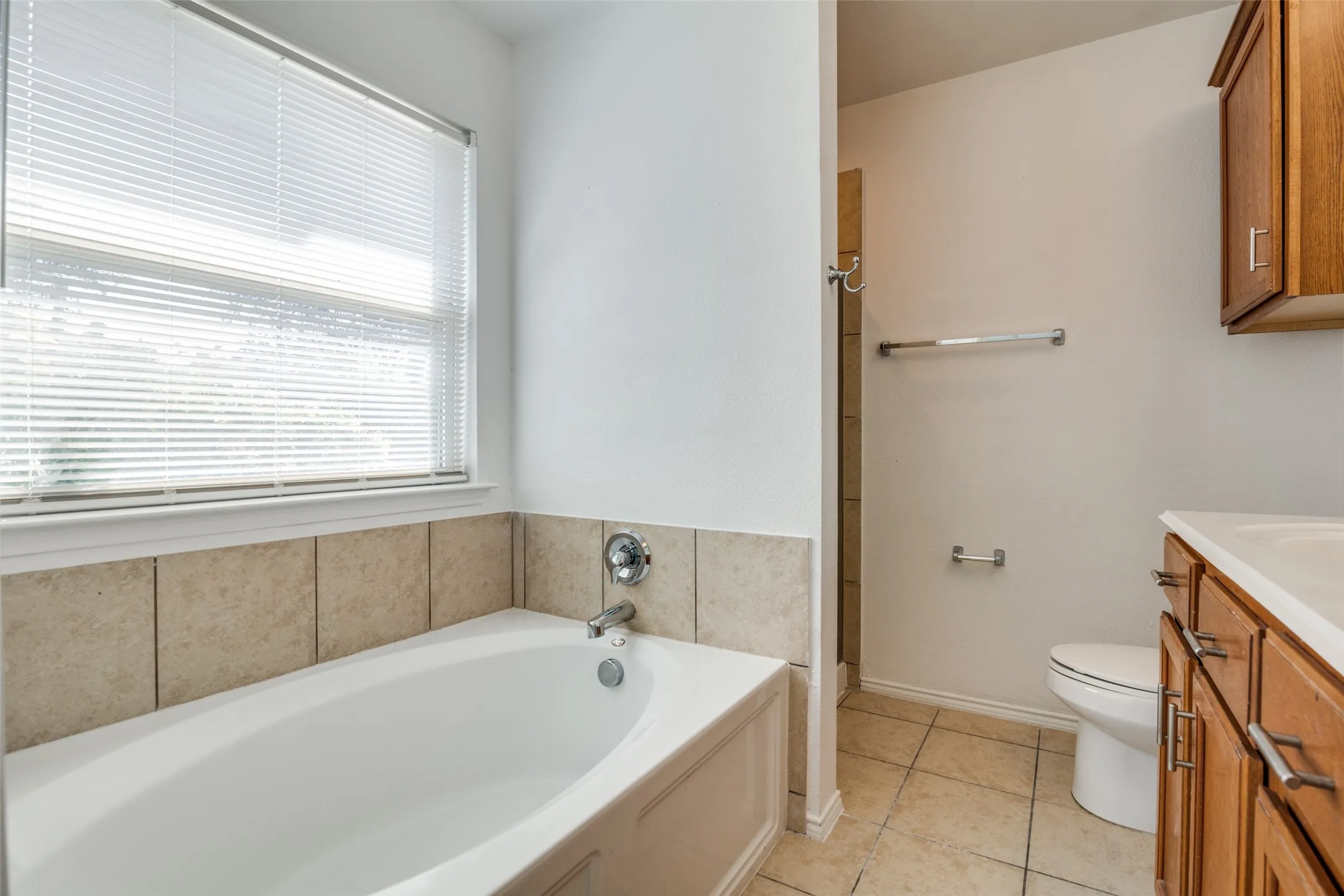 Bathroom with a bathing tub, toilet, vanity, and tile patterned floors