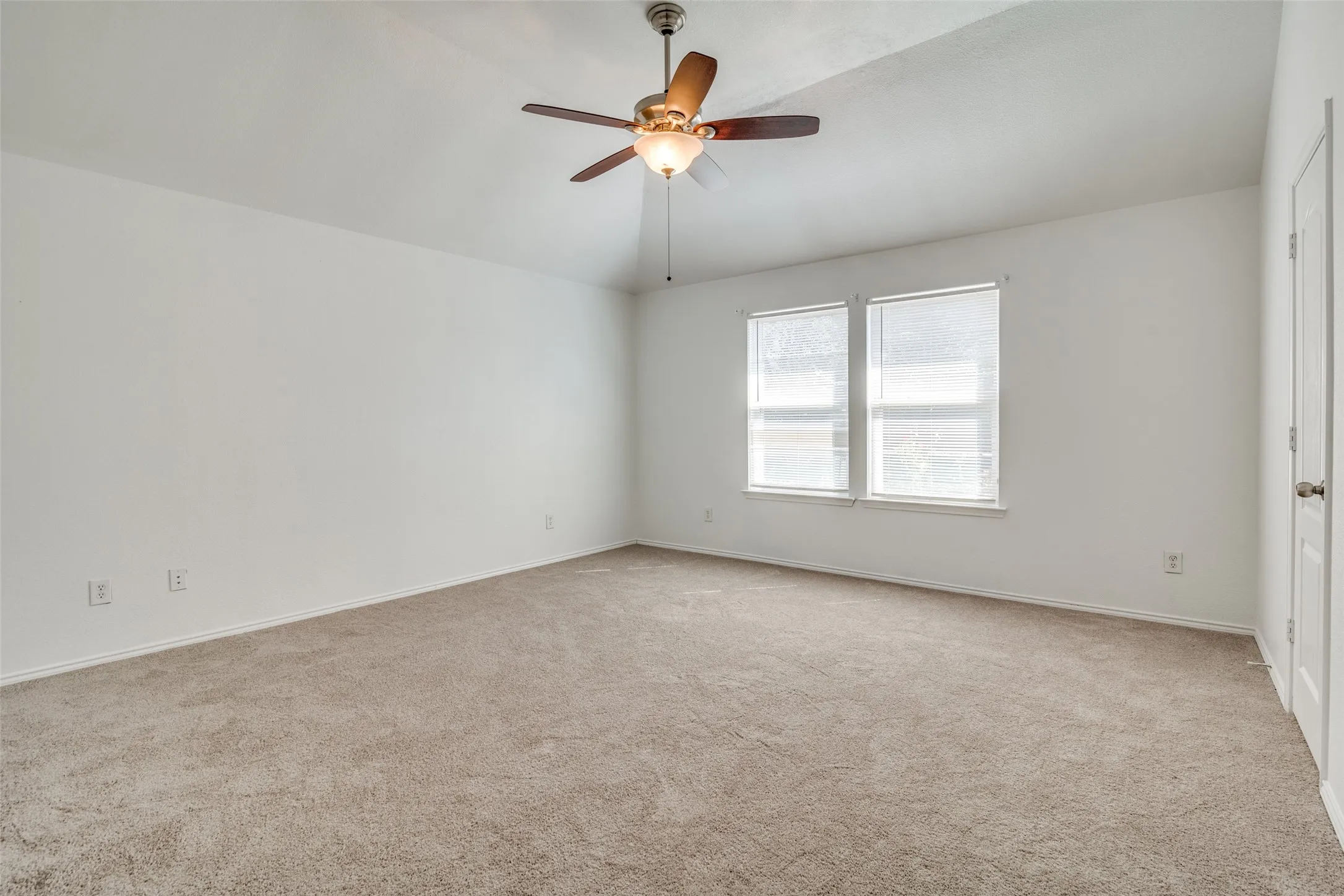 Carpeted spare room featuring ceiling fan