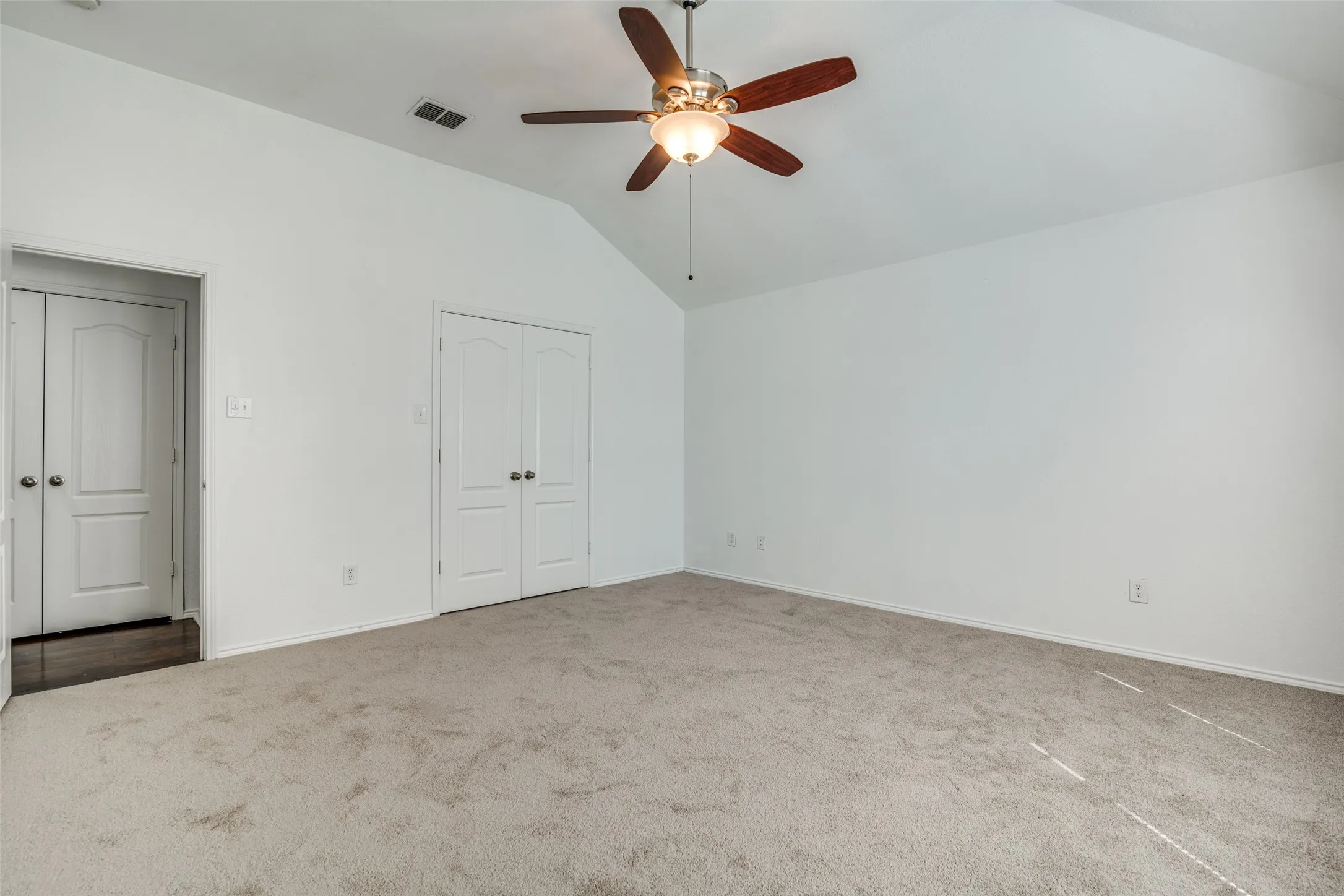 Unfurnished bedroom with lofted ceiling, carpet, and ceiling fan