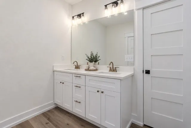 Virtual staging - Dual vanity with white cabinetry, bronze-finish faucets, and an expansive mirror