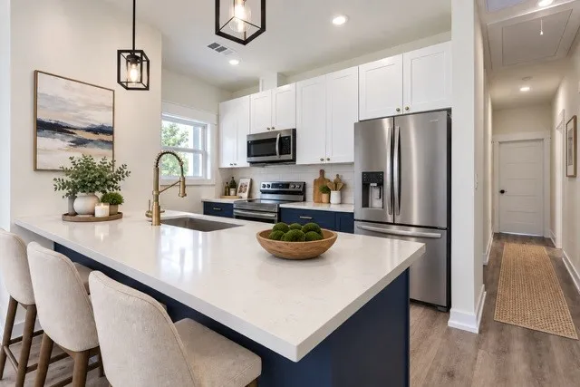 Virtual staging - Kitchen featuring a white countertop island, stainless steel appliances, white upper cabinetry, and blue lower cabinetry
