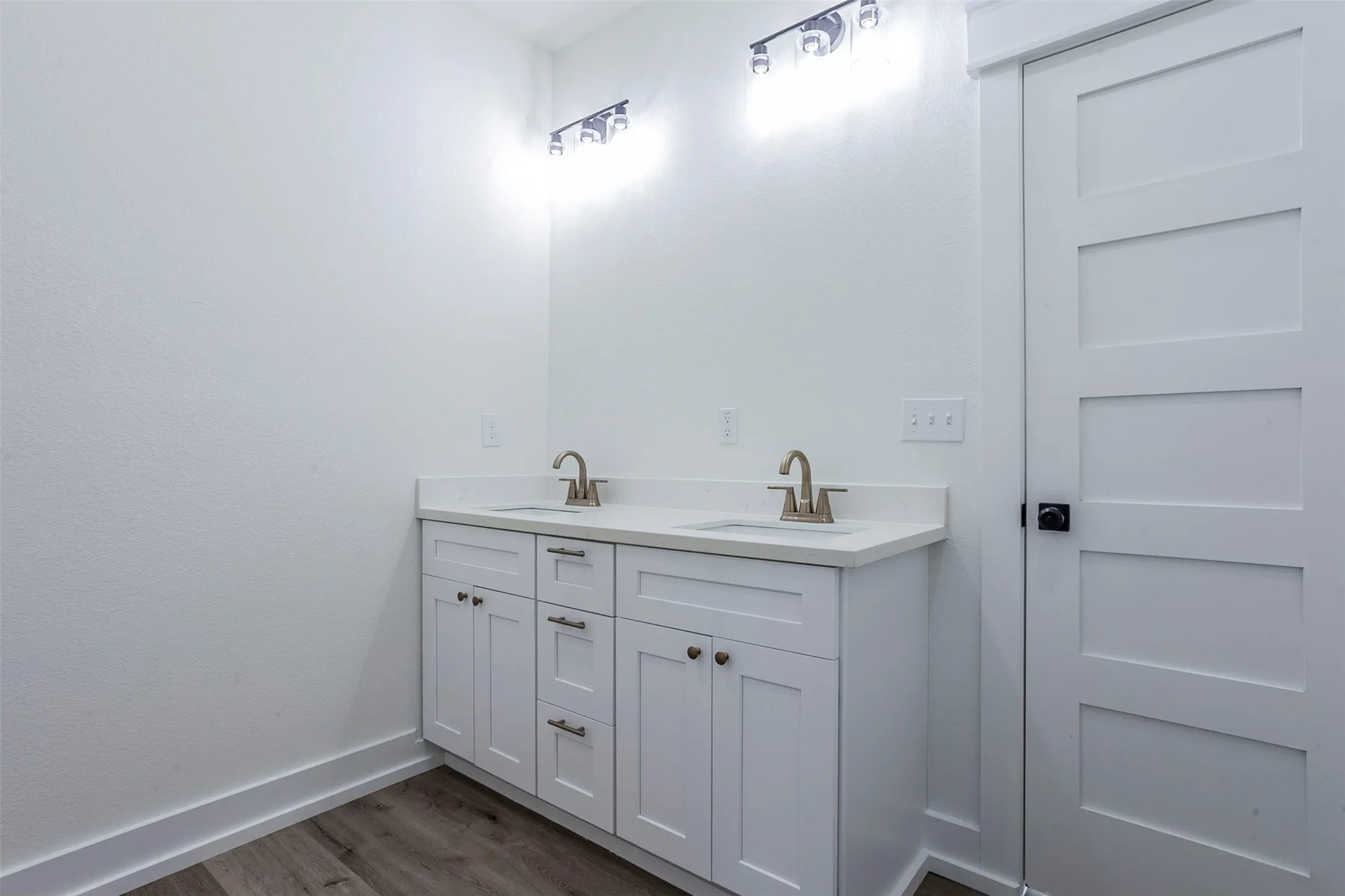 Double vanity with white cabinetry, light-toned countertops, and brushed nickel faucets