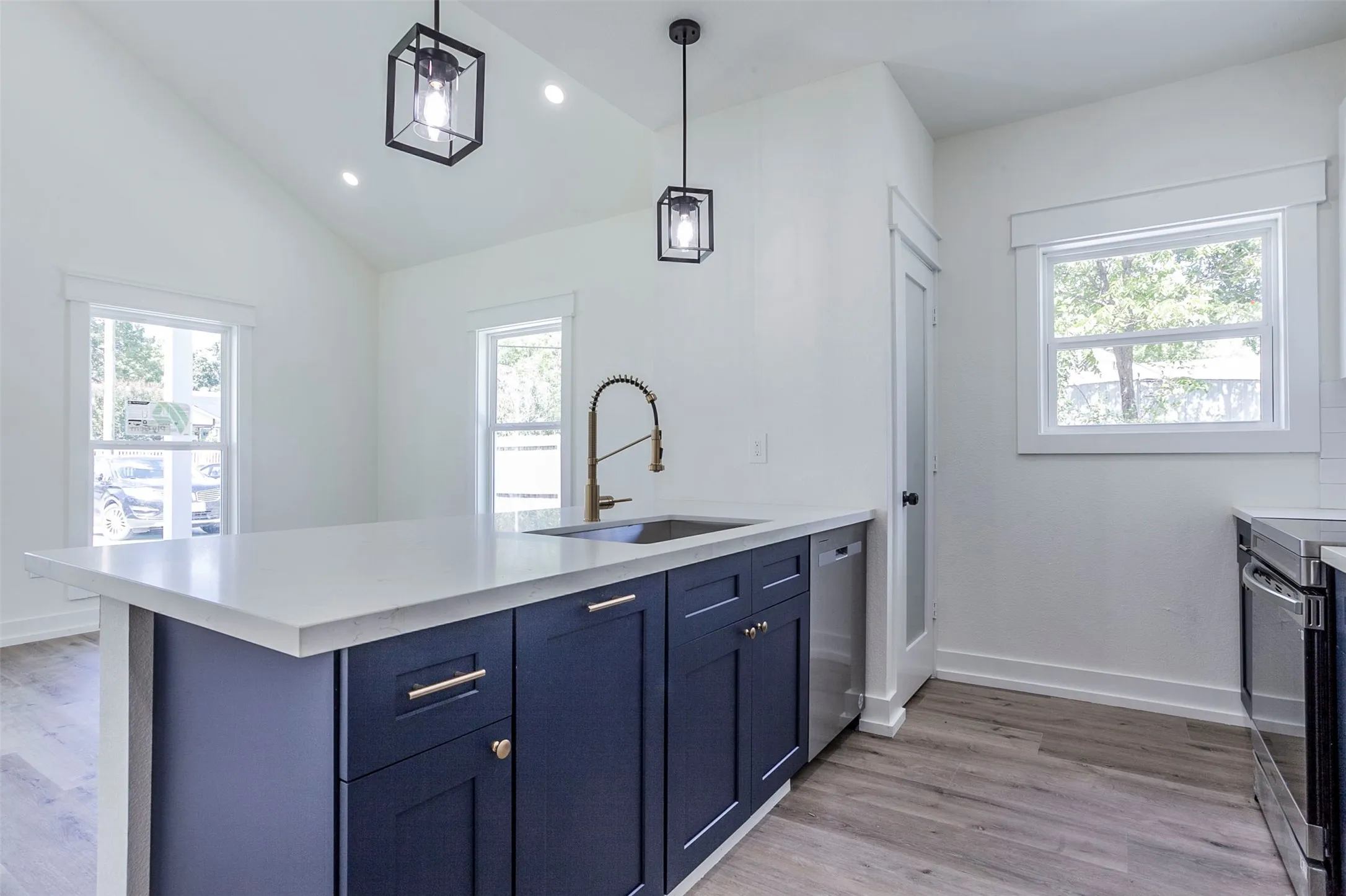 Kitchen island with white countertop, dark blue cabinetry, and brass hardware