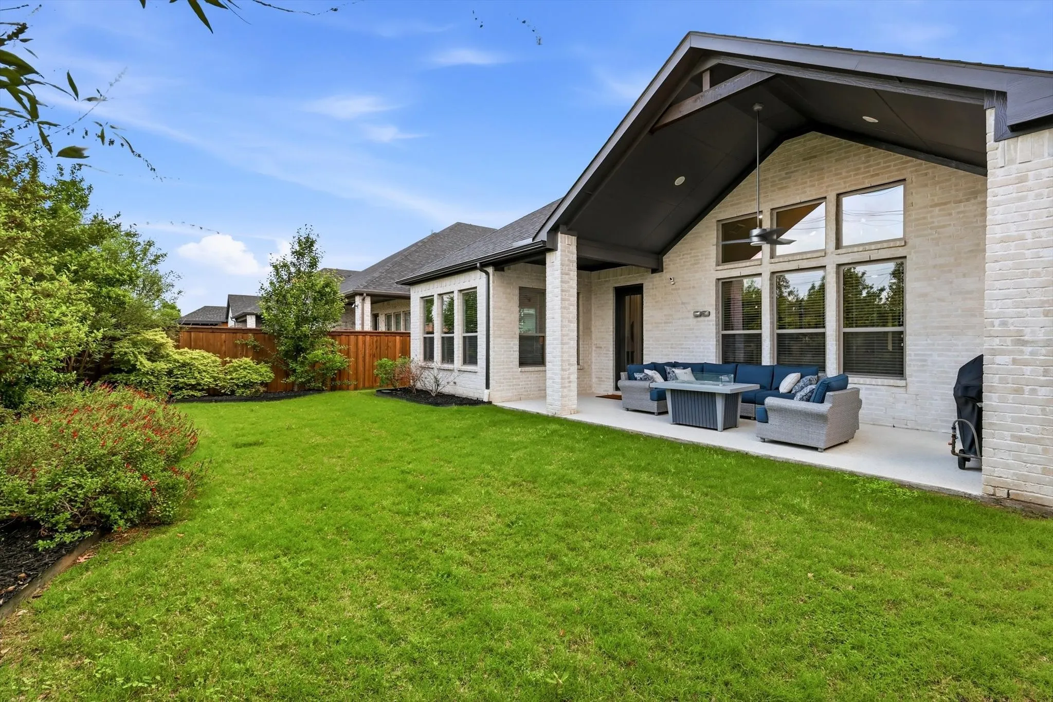 Private backyard oasis, complete with an epoxy-coated covered patio, gas stub for grilling, and beautifully designed custom landscaping.