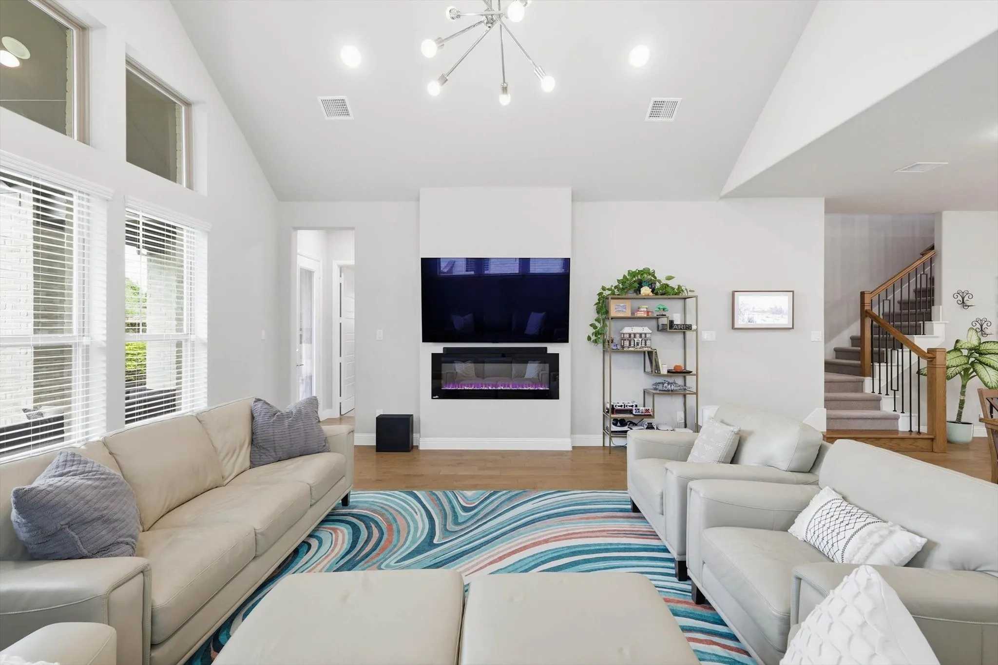 Expansive family room features vaulted ceilings with a custom cedar beam, & a designer fireplace.