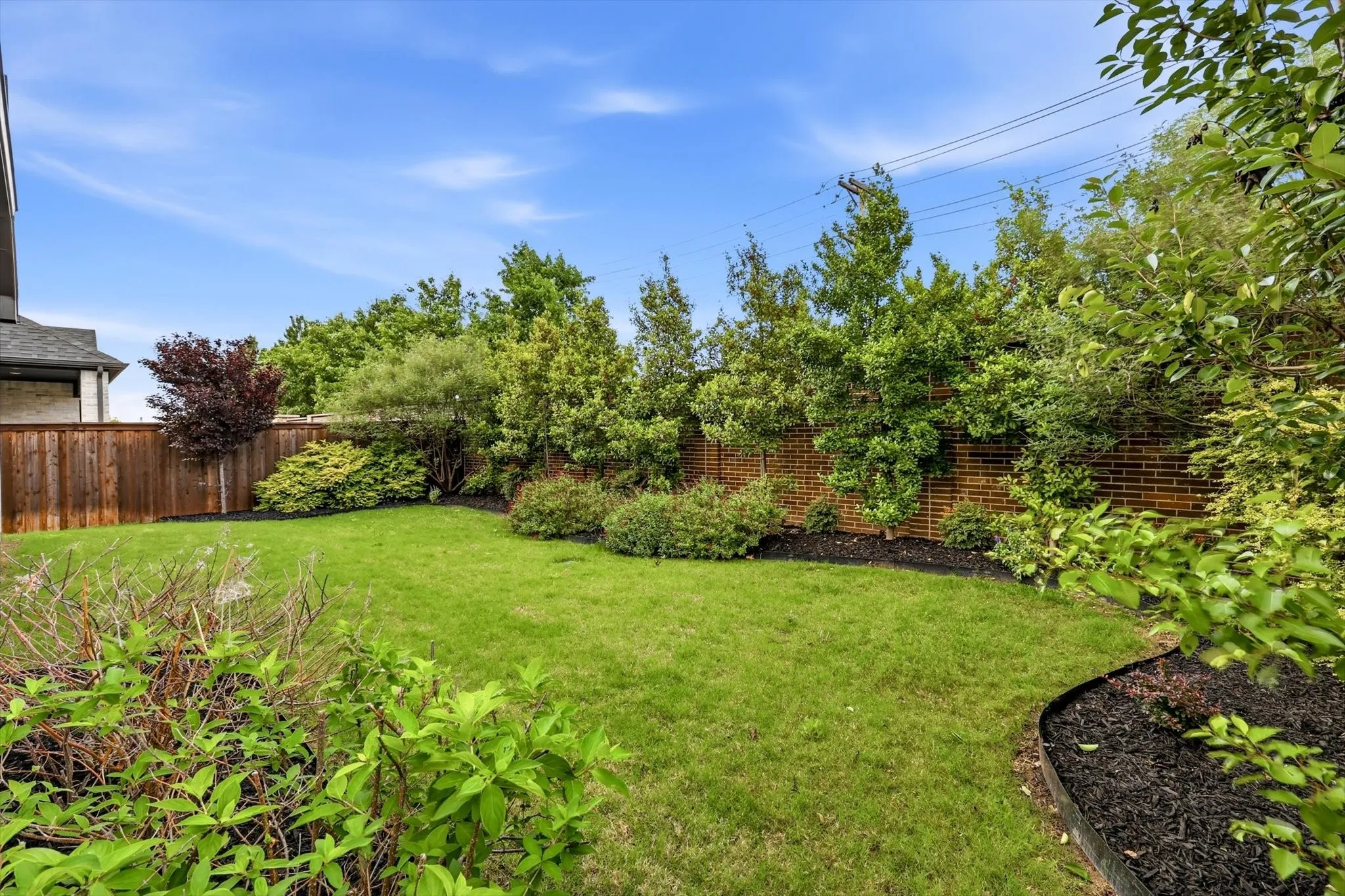 Private backyard oasis, complete with an epoxy-coated covered patio, gas stub for grilling, and beautifully designed custom landscaping.