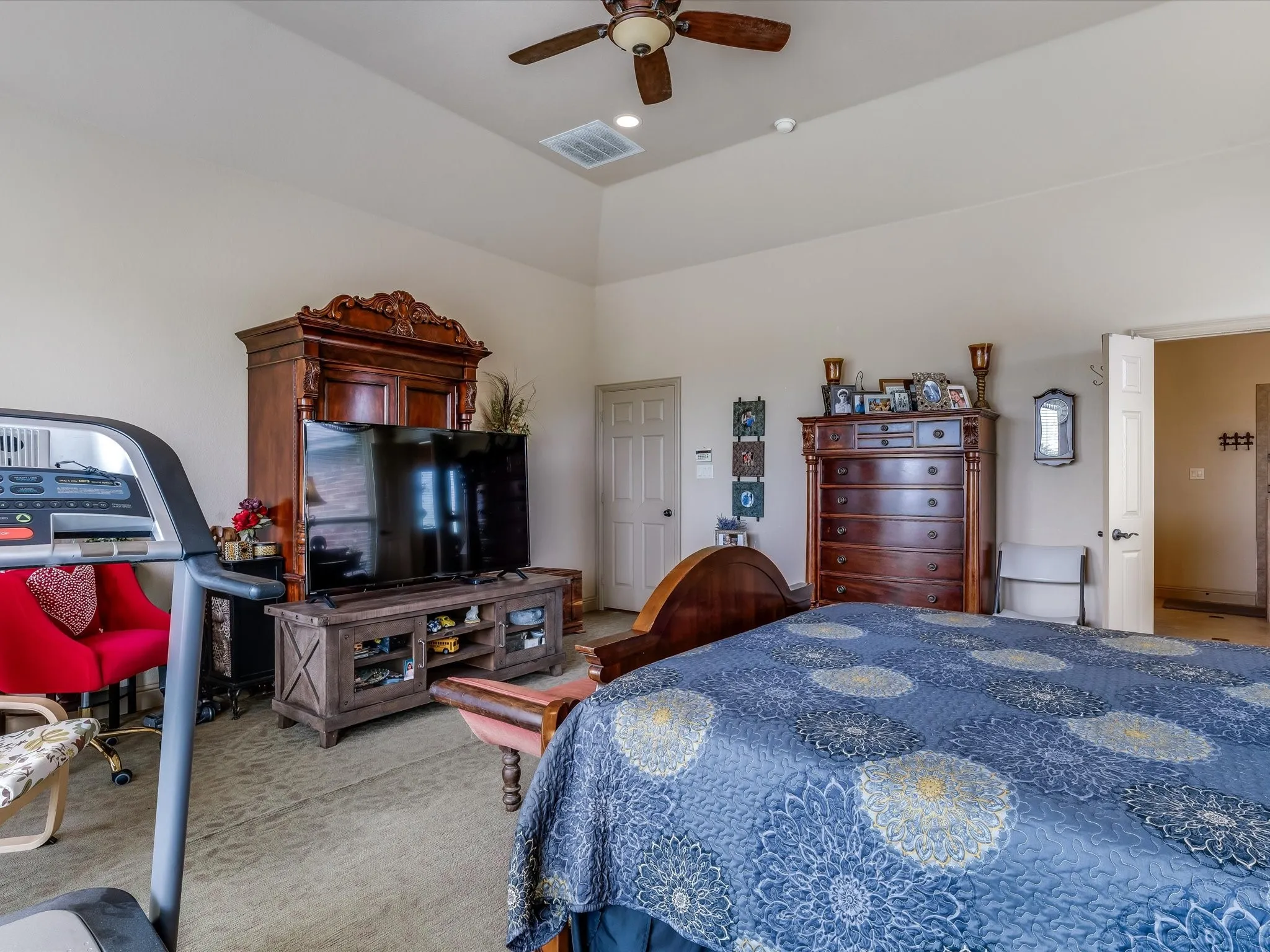 Spacious room featuring vaulted ceilings, a ceiling fan, and carpeted flooring