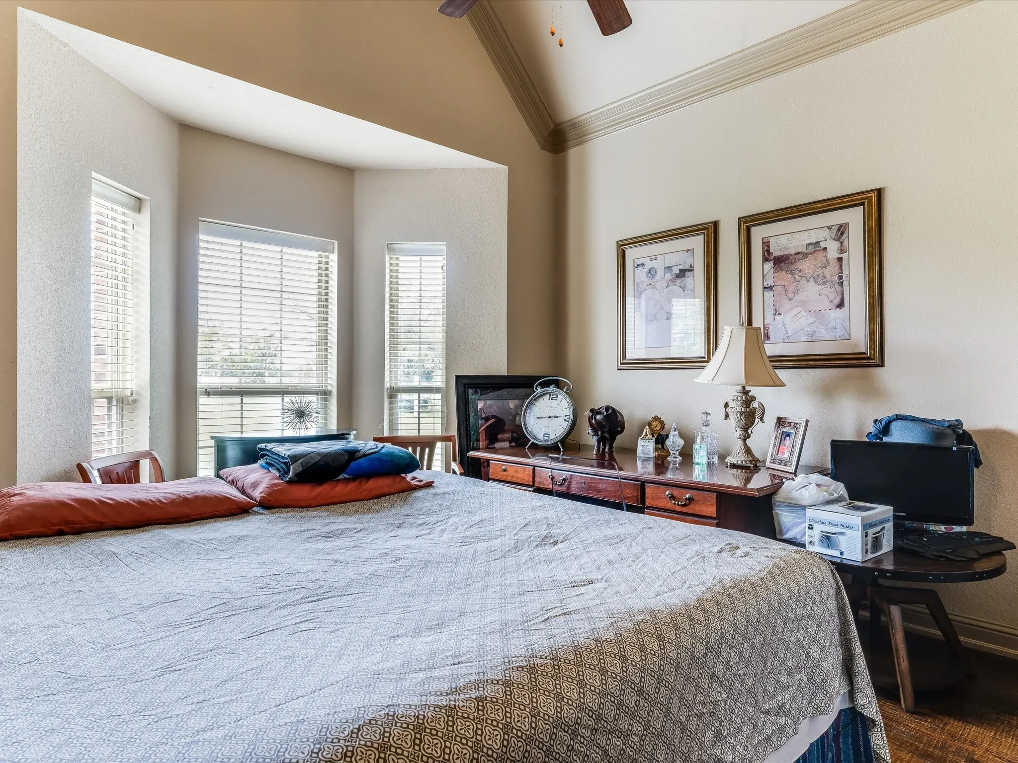 Bay window with multiple windows, crown molding, and a vaulted ceiling