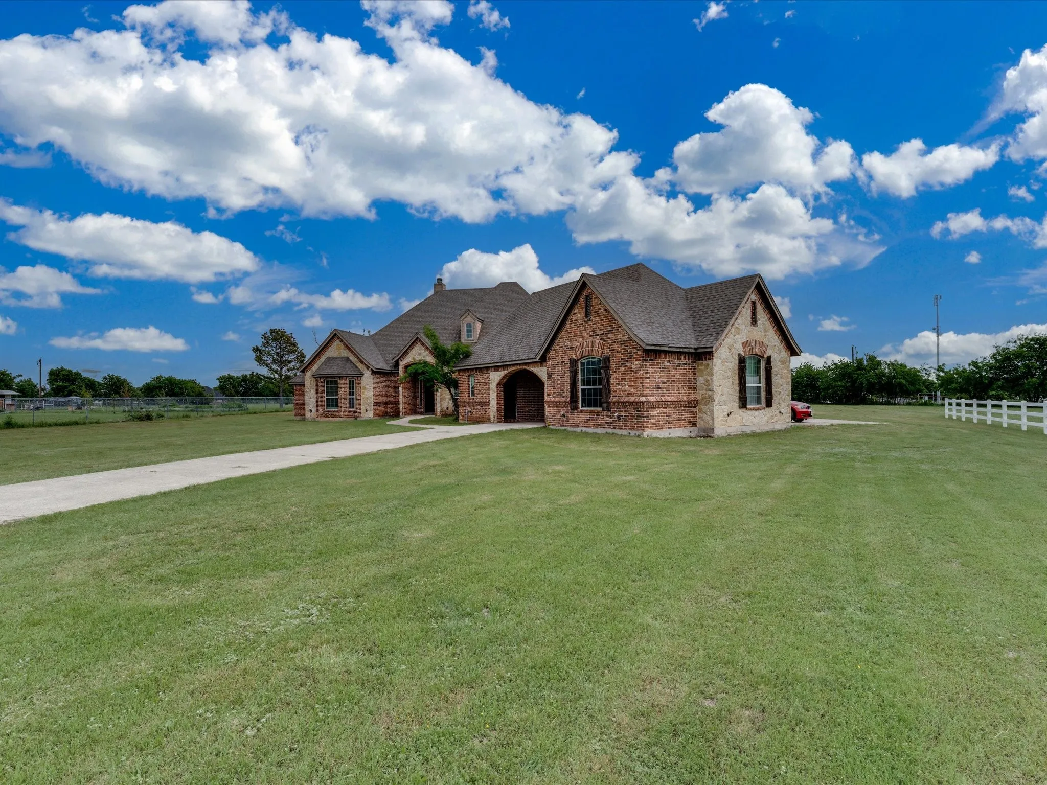 Spacious property featuring a large brick and stone exterior home with a gabled roof