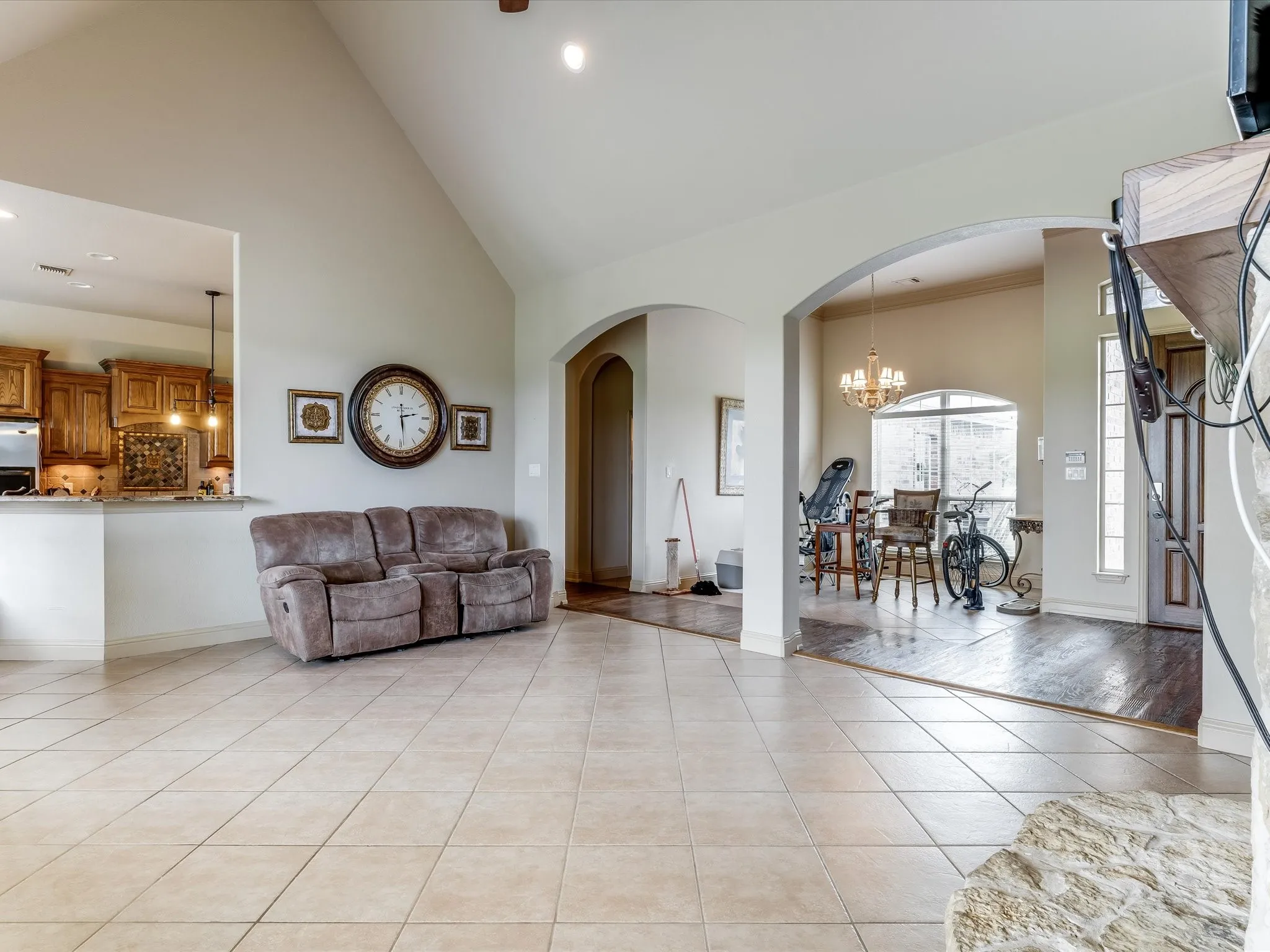 Spacious interior featuring vaulted ceilings and neutral tile flooring