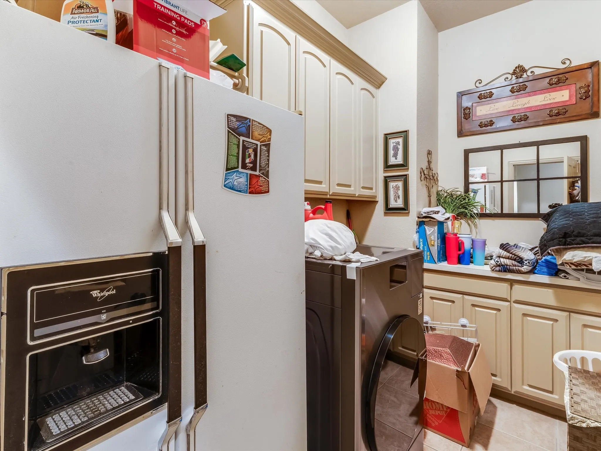 Utility room featuring upper and lower cabinetry, a built-in countertop, and tile flooring