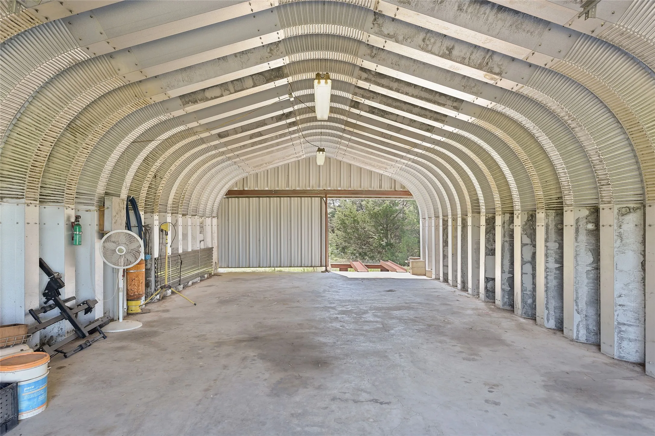 21'X40', 4-car Quonset hut with electricity, compressed air, and a drive-out ramp. Offers ample storage and workspace.