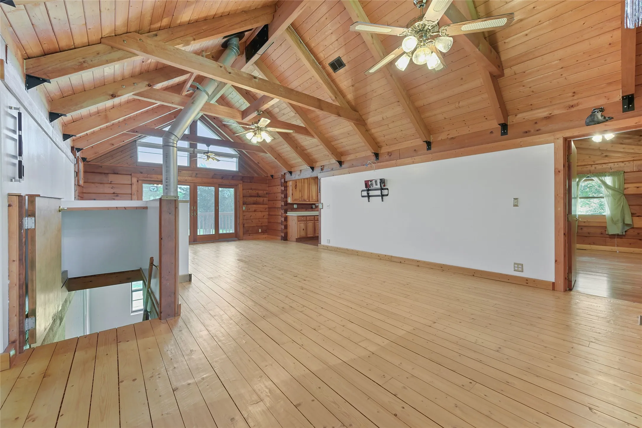 Without Virtual Staging. With view of stairs to lower level with walkout, Exterior windows with electric shades, Kitchen, and entrance to Primary Bedroom.