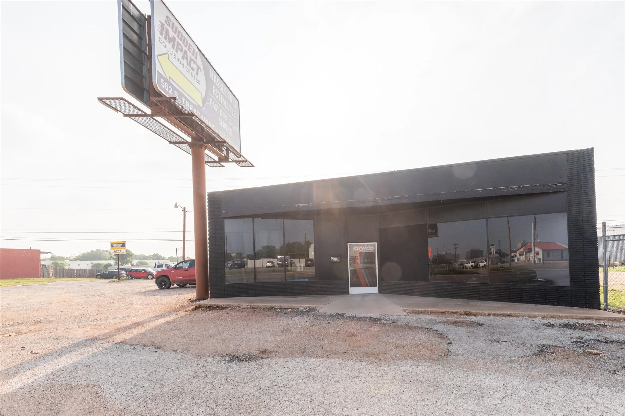 Commercial storefront building featuring a prominent billboard, expansive front windows, and a dedicated entrance