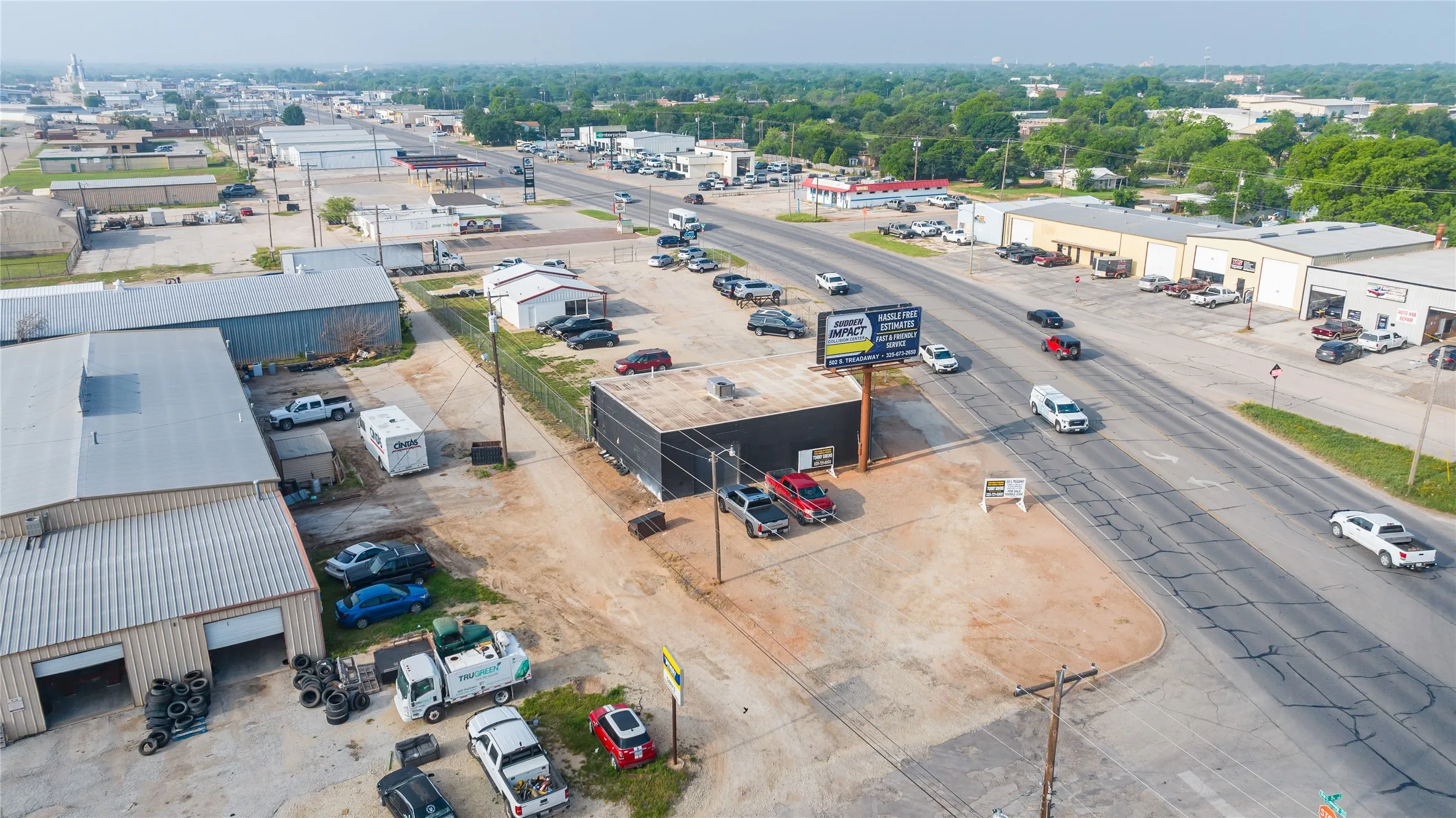 Commercial property featuring a dark-colored building with an adjacent parking area and a prominent billboard