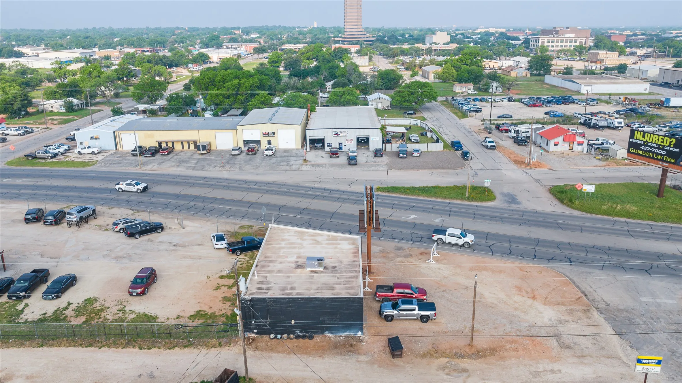 Property featuring a commercial building with a flat roof and dark exterior, positioned at a road intersection