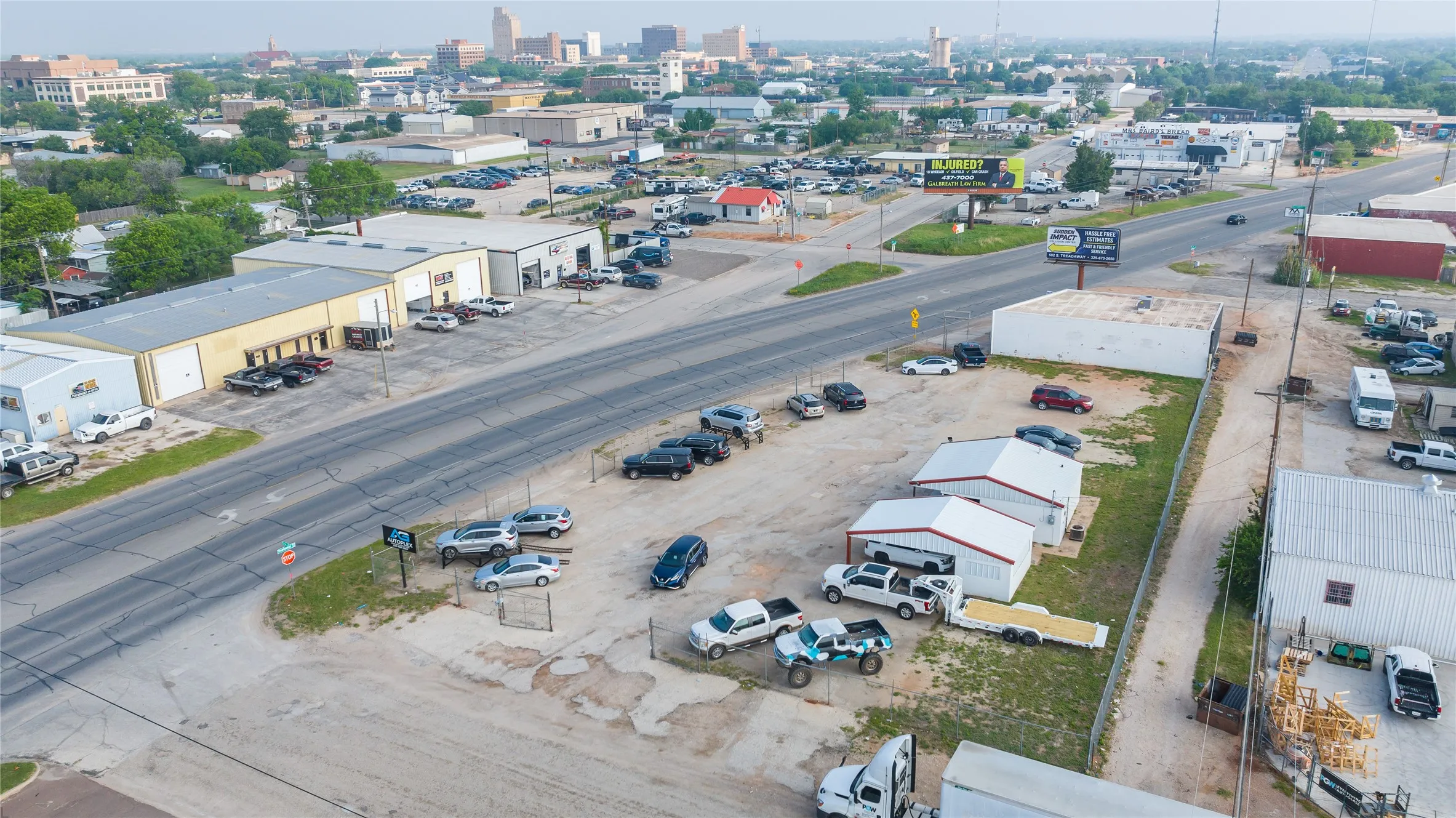Aerial perspective showcasing multiple commercial structures and ample paved and unpaved parking areas