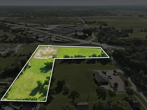 Expansive parcel featuring open green fields and mature tree lines