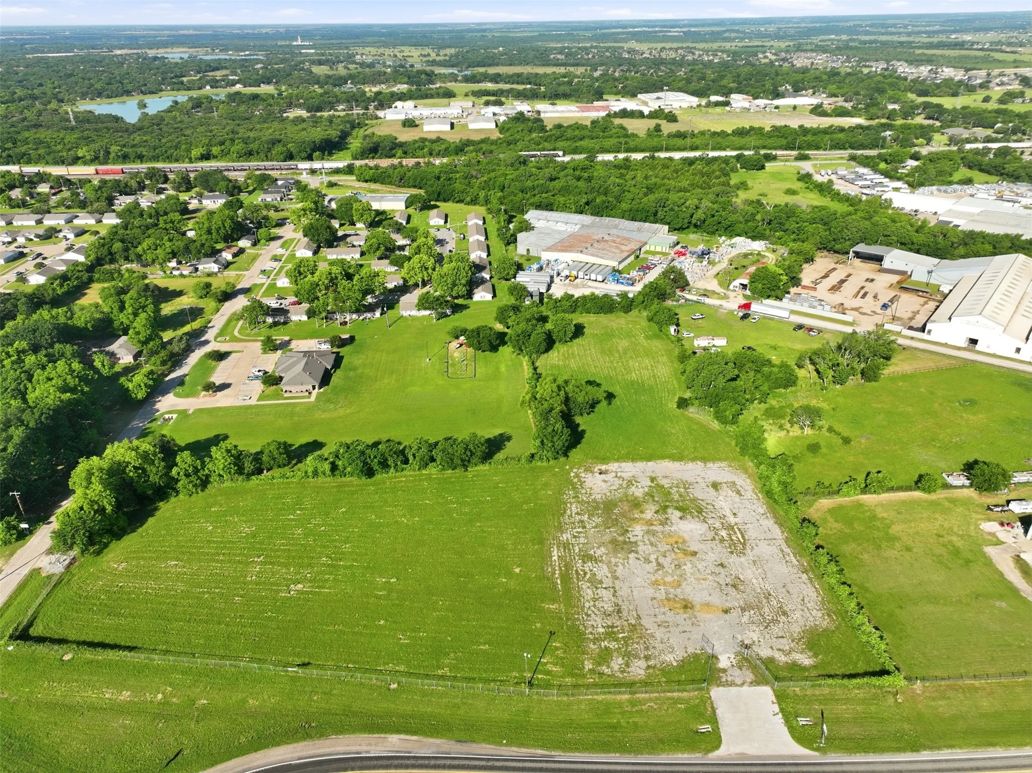 Expansive land parcel featuring substantial green space and a partial-paved area