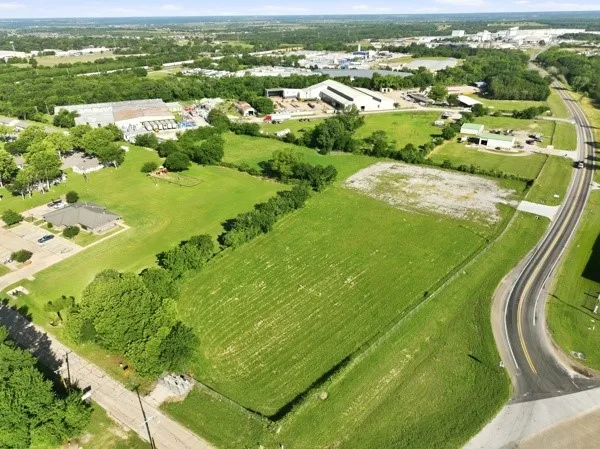Expansive undeveloped land parcel featuring a partially cleared area and direct road frontage
