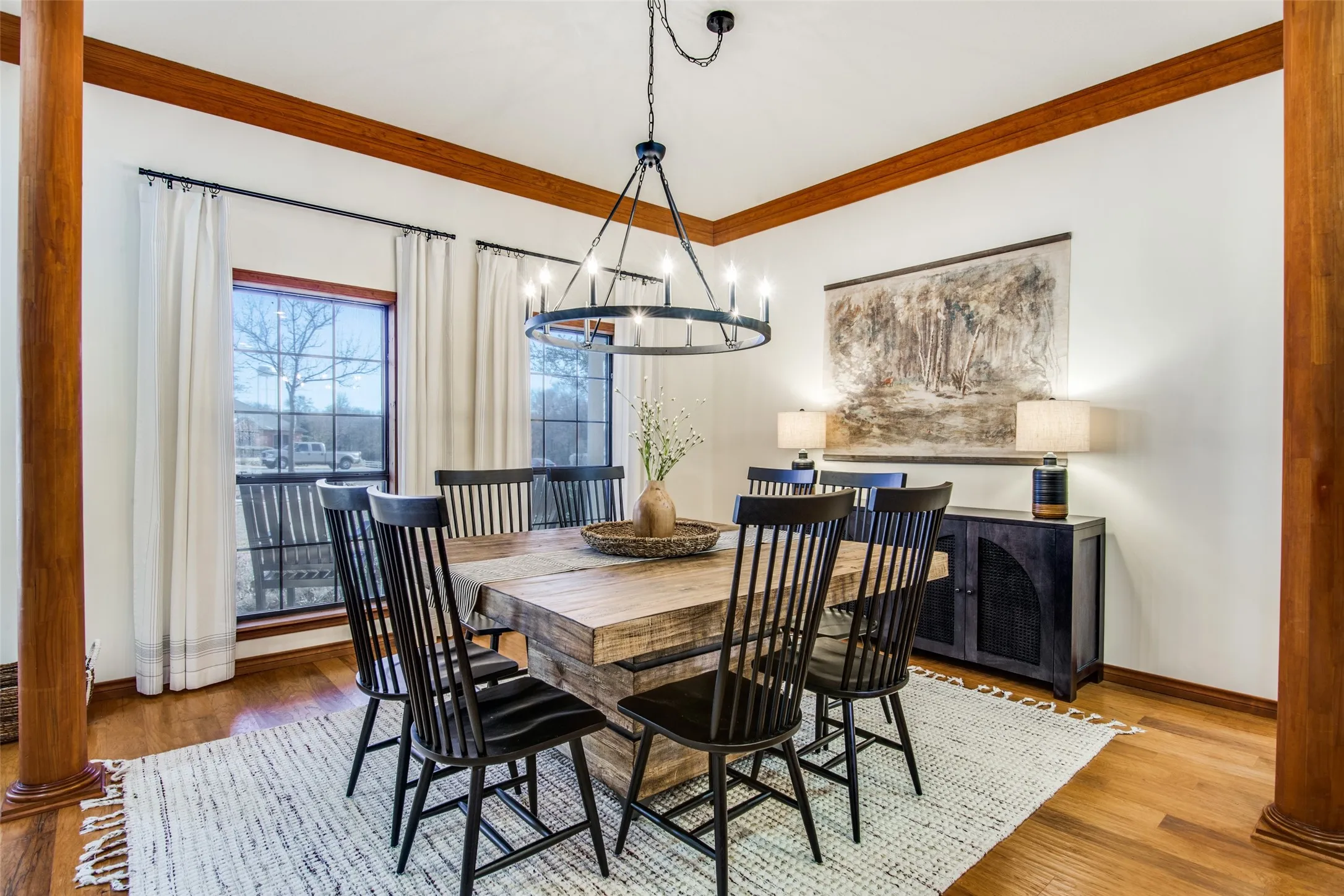 Dining space featuring a substantial wood-finish table, wood-finish flooring, and a wrought iron chandelier