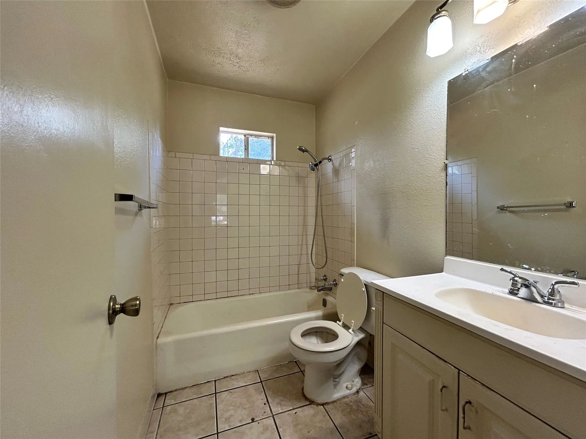 Vanity with a white countertop and integrated sink, chrome faucet, and cabinet storage