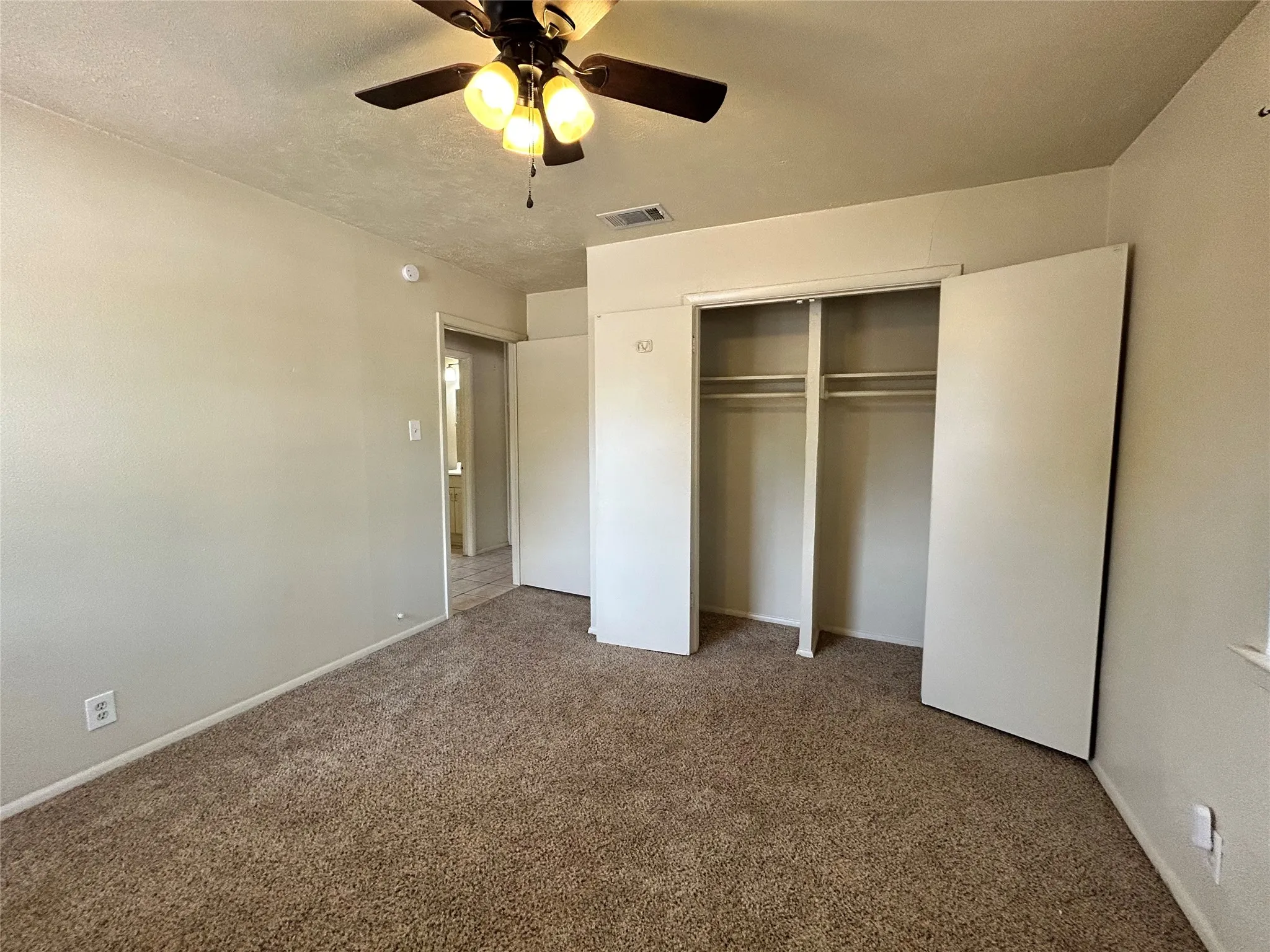 Neutral-toned walls complement the carpeted flooring