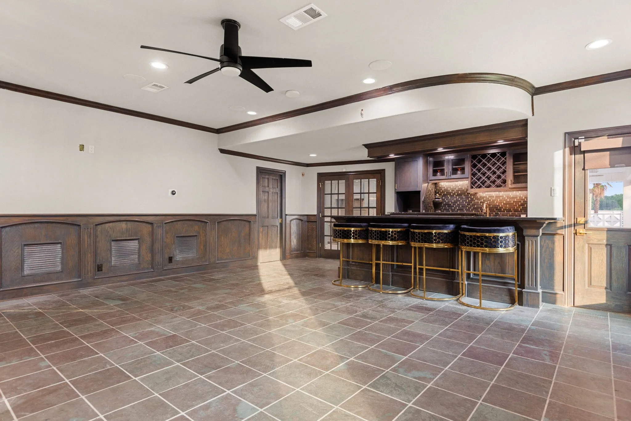 Spacious entertainment area featuring a built-in bar with dark wood cabinetry and a wine rack
